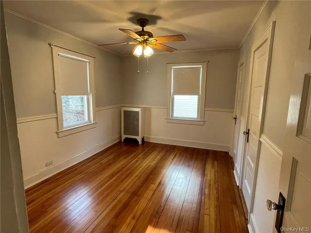 Bedroom 2 featuring hardwood floors, closet space and fan. Bedroom 2 featuring hardwood floors, closet space and fan.