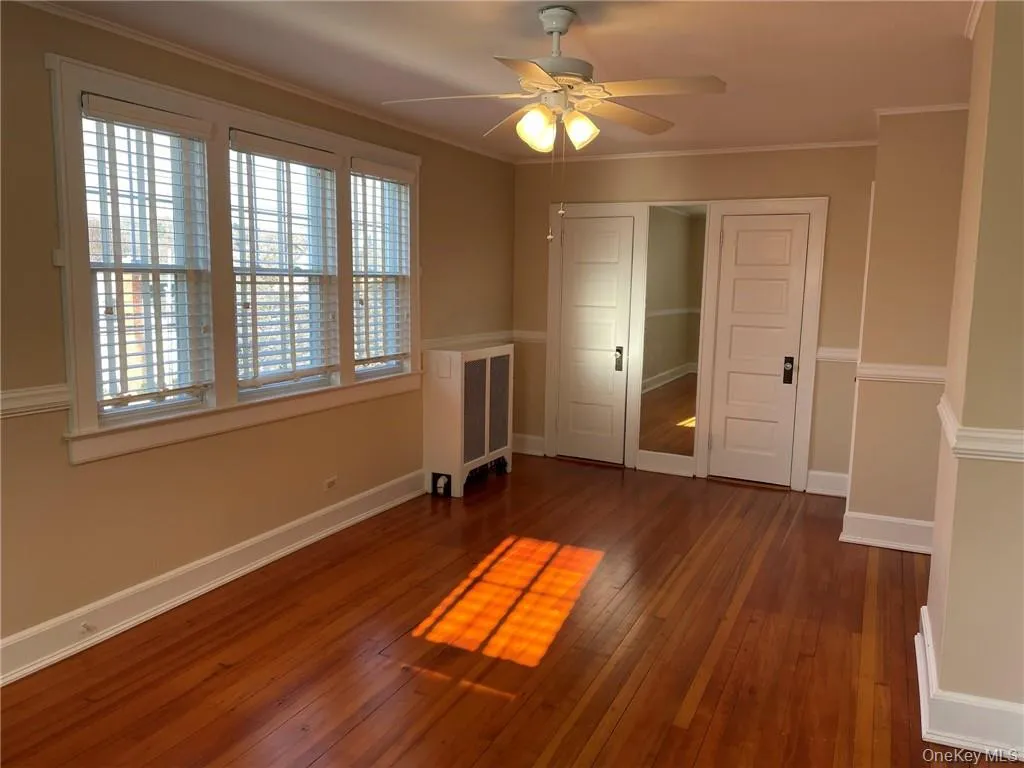 Primary bedroom featuring hardwood floors, closet space and fan. Primary bedroom featuring hardwood floors, closet space and fan.