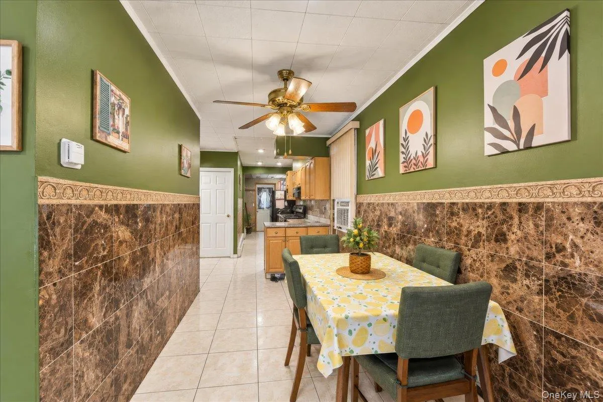 Tiled flooring, wainscoting with decorative trim, ceiling fan, and built-in cabinetry Tiled flooring, wainscoting with decorative trim, ceiling fan, and built-in cabinetry
