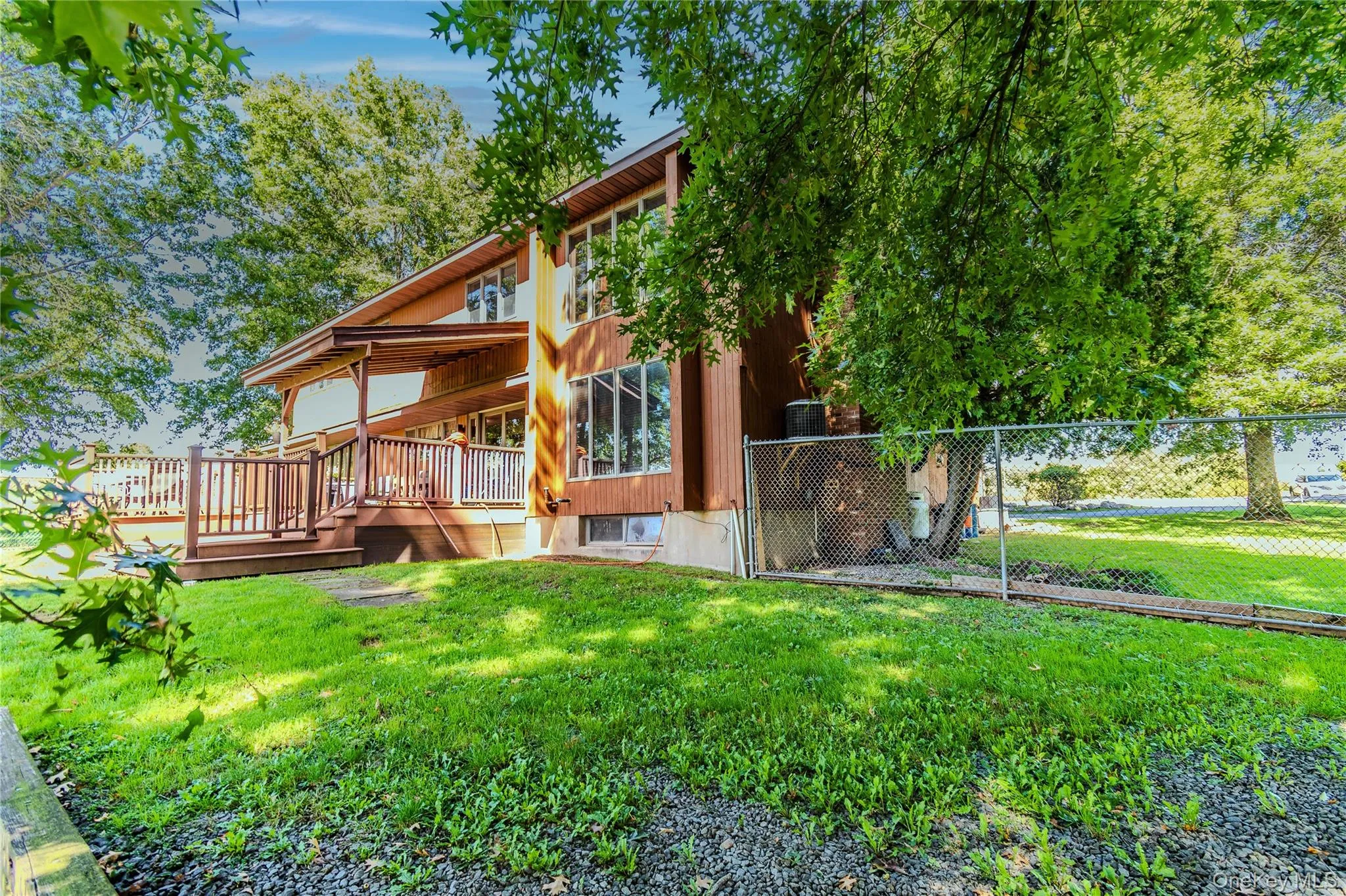 Multi-level exterior with wood siding, expansive wood deck, and abundant windows Multi-level exterior with wood siding, expansive wood deck, and abundant windows