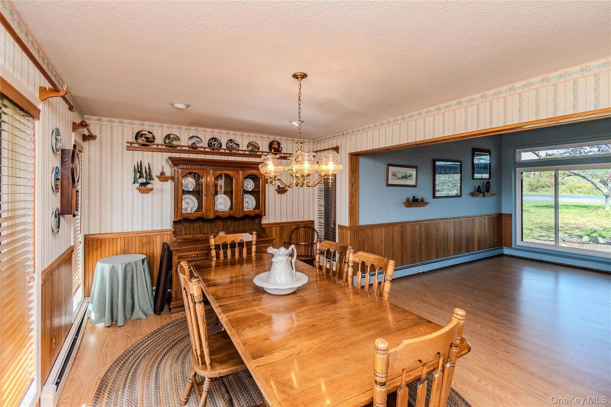 Wood-finish flooring throughout, featuring a chandelier light fixture Wood-finish flooring throughout, featuring a chandelier light fixture