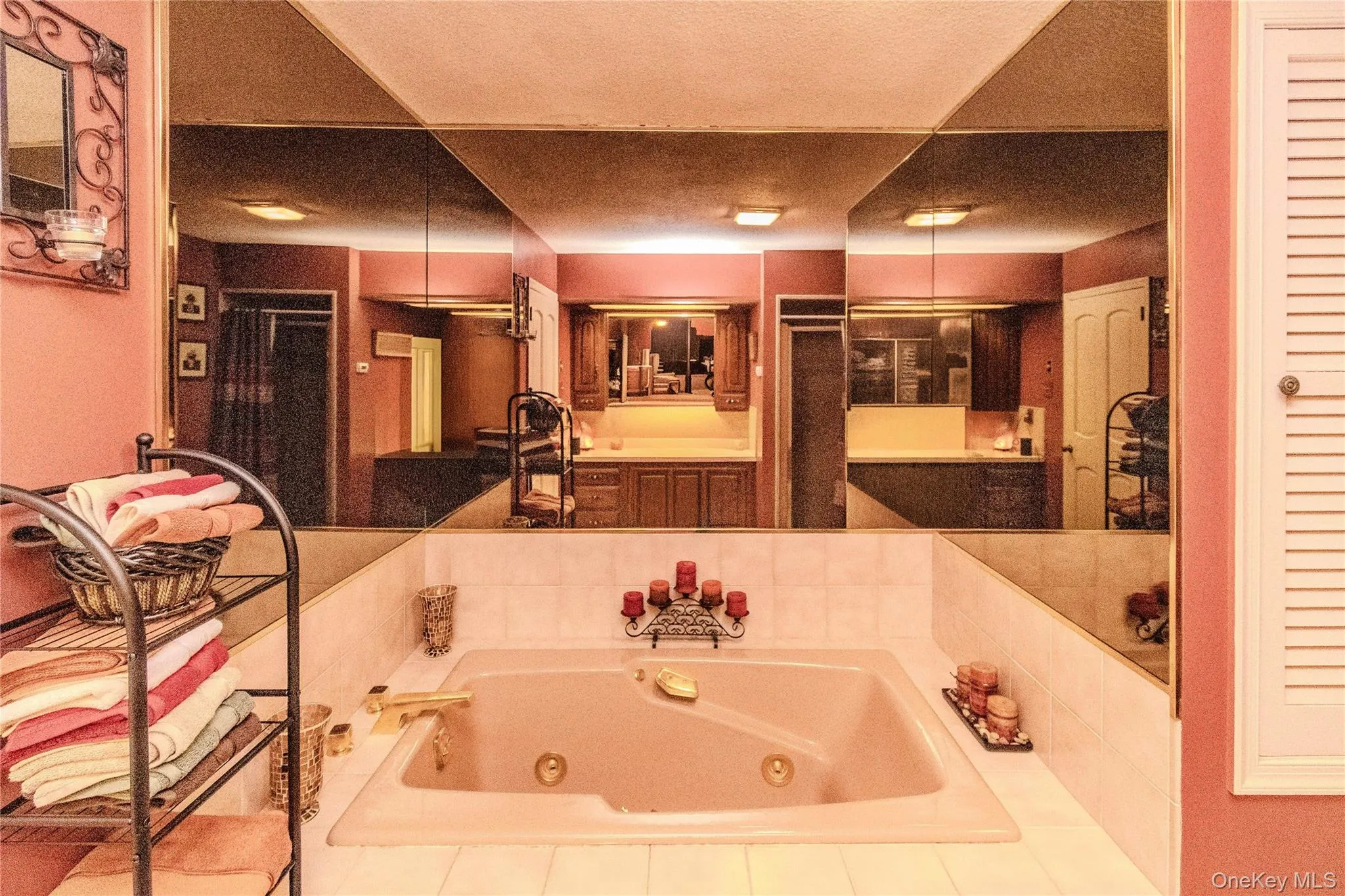 Jetted tub with gold-tone fixtures, surrounded by white tiled decking Jetted tub with gold-tone fixtures, surrounded by white tiled decking