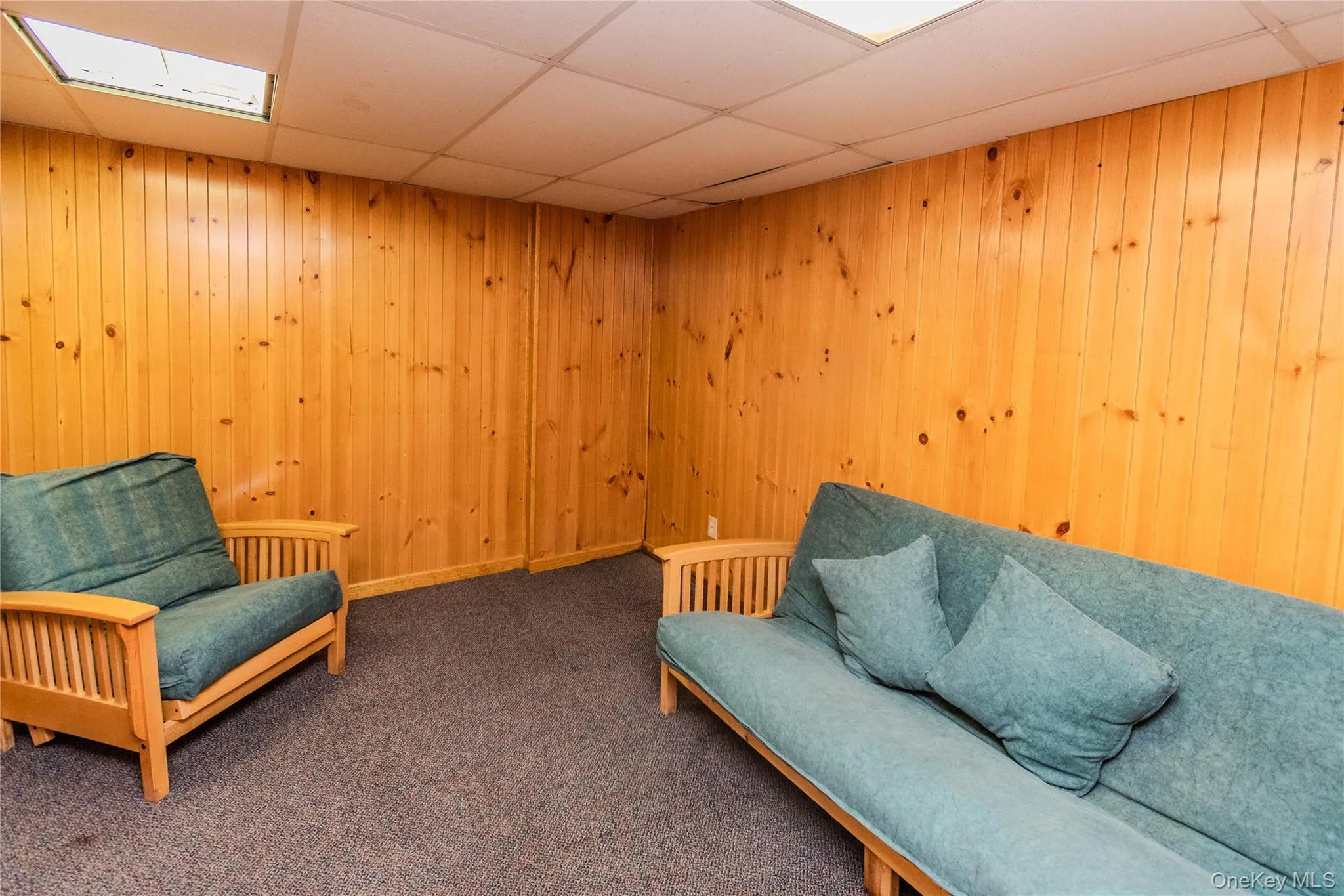 Wood-paneled walls with a drop ceiling and recessed lighting Wood-paneled walls with a drop ceiling and recessed lighting