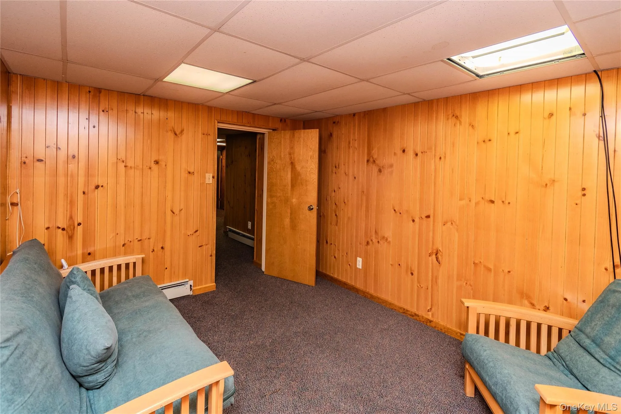 Wood paneling accentuates the walls, complemented by a drop ceiling with integrated lighting Wood paneling accentuates the walls, complemented by a drop ceiling with integrated lighting