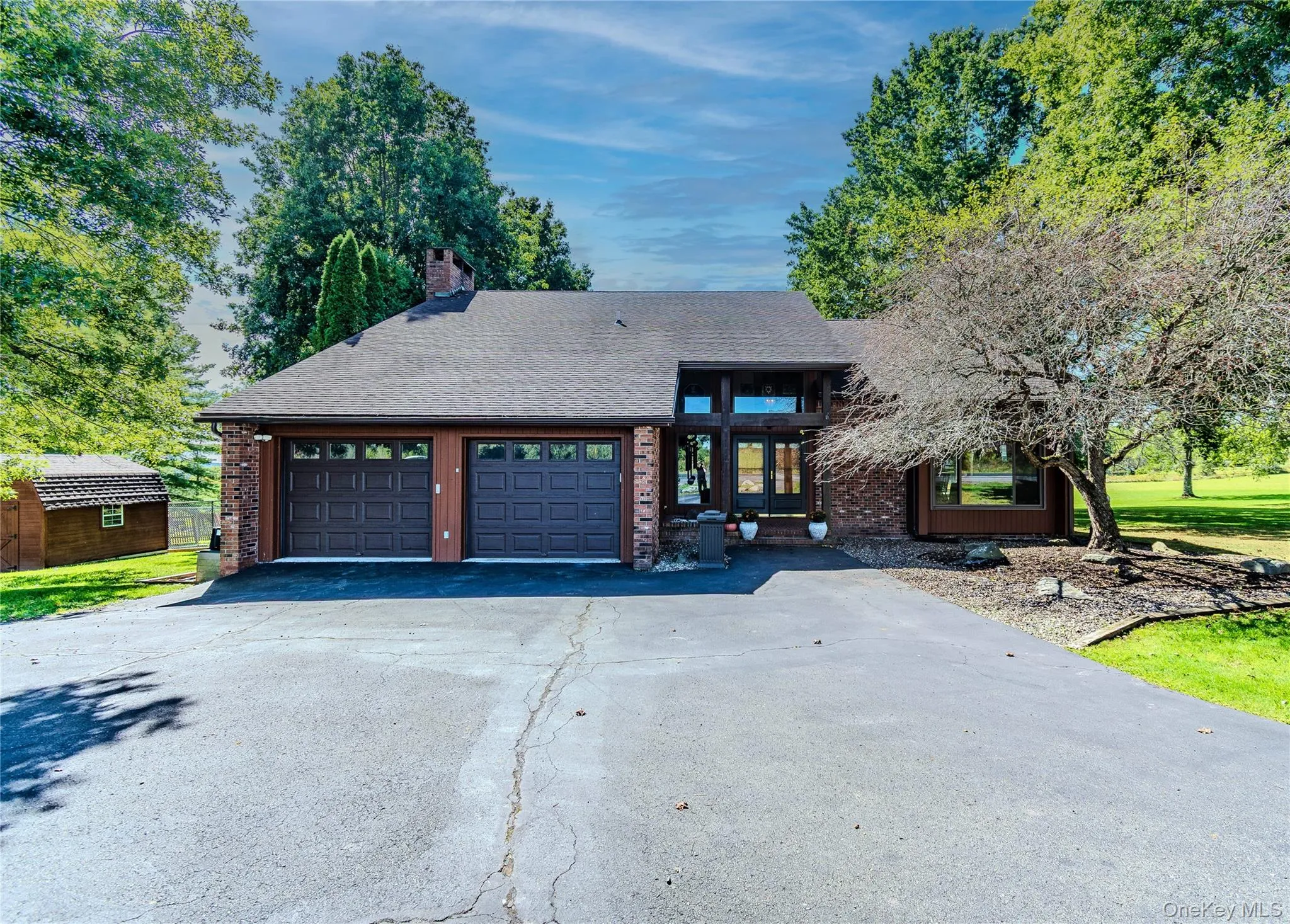 Brick facade with dual attached garage featuring panel doors and window inserts Brick facade with dual attached garage featuring panel doors and window inserts