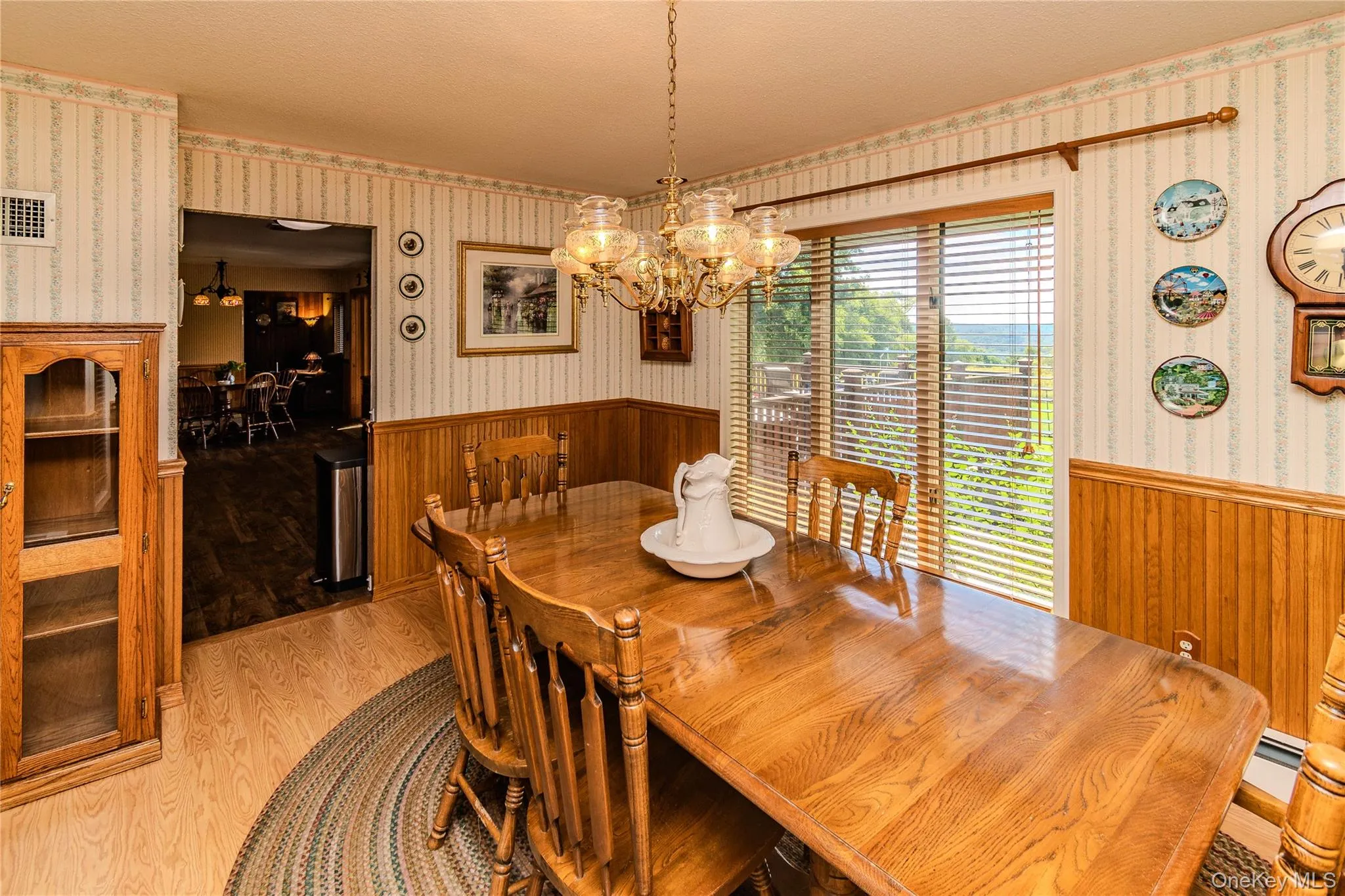 Dining area featuring wood-finish flooring and wainscoting Dining area featuring wood-finish flooring and wainscoting