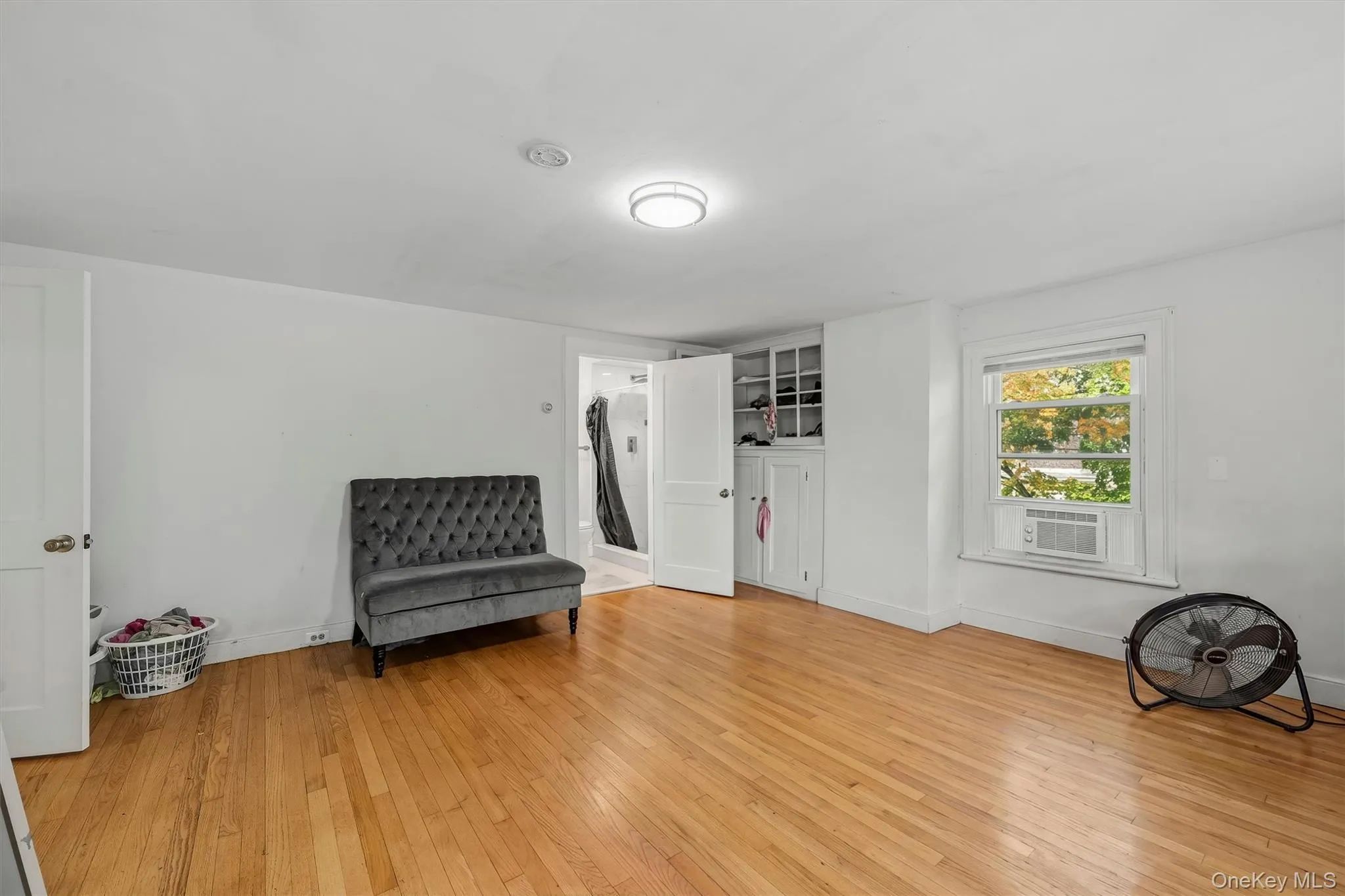 Wood-finish flooring with white walls and a built-in storage cabinet Wood-finish flooring with white walls and a built-in storage cabinet