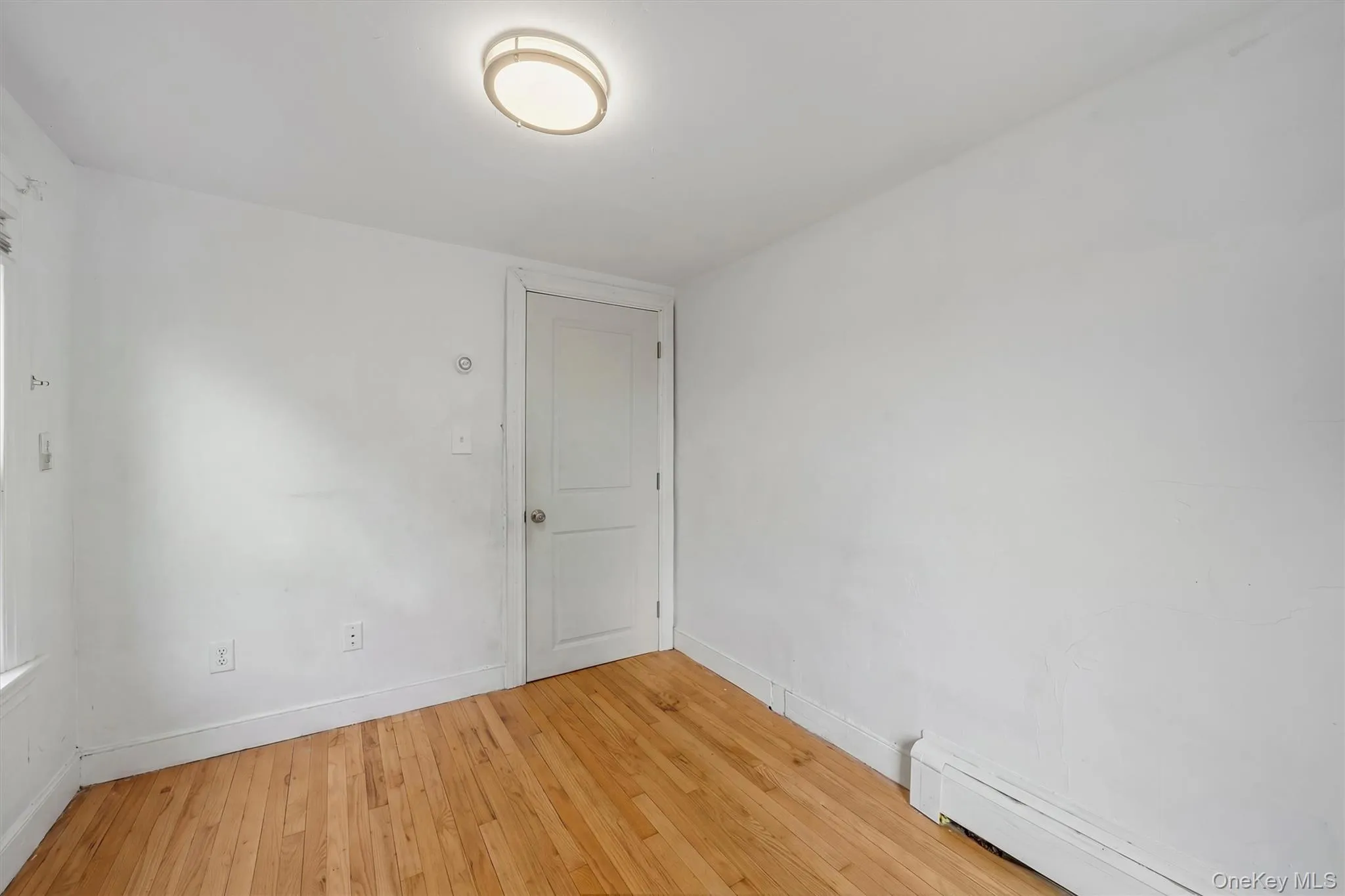Hardwood flooring, painted walls, flush-mount ceiling light, and baseboard heating Hardwood flooring, painted walls, flush-mount ceiling light, and baseboard heating