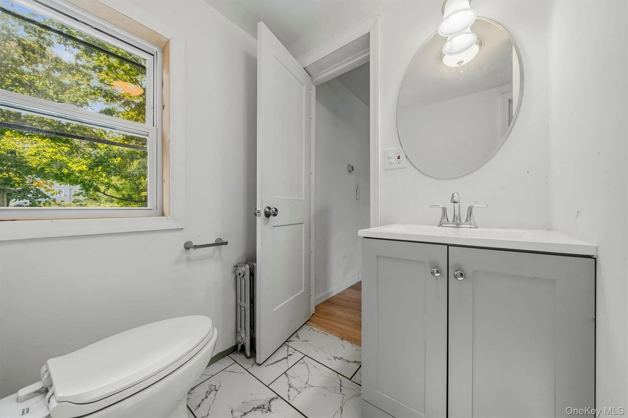 White vanity with a corner-fit countertop and undermount sink White vanity with a corner-fit countertop and undermount sink