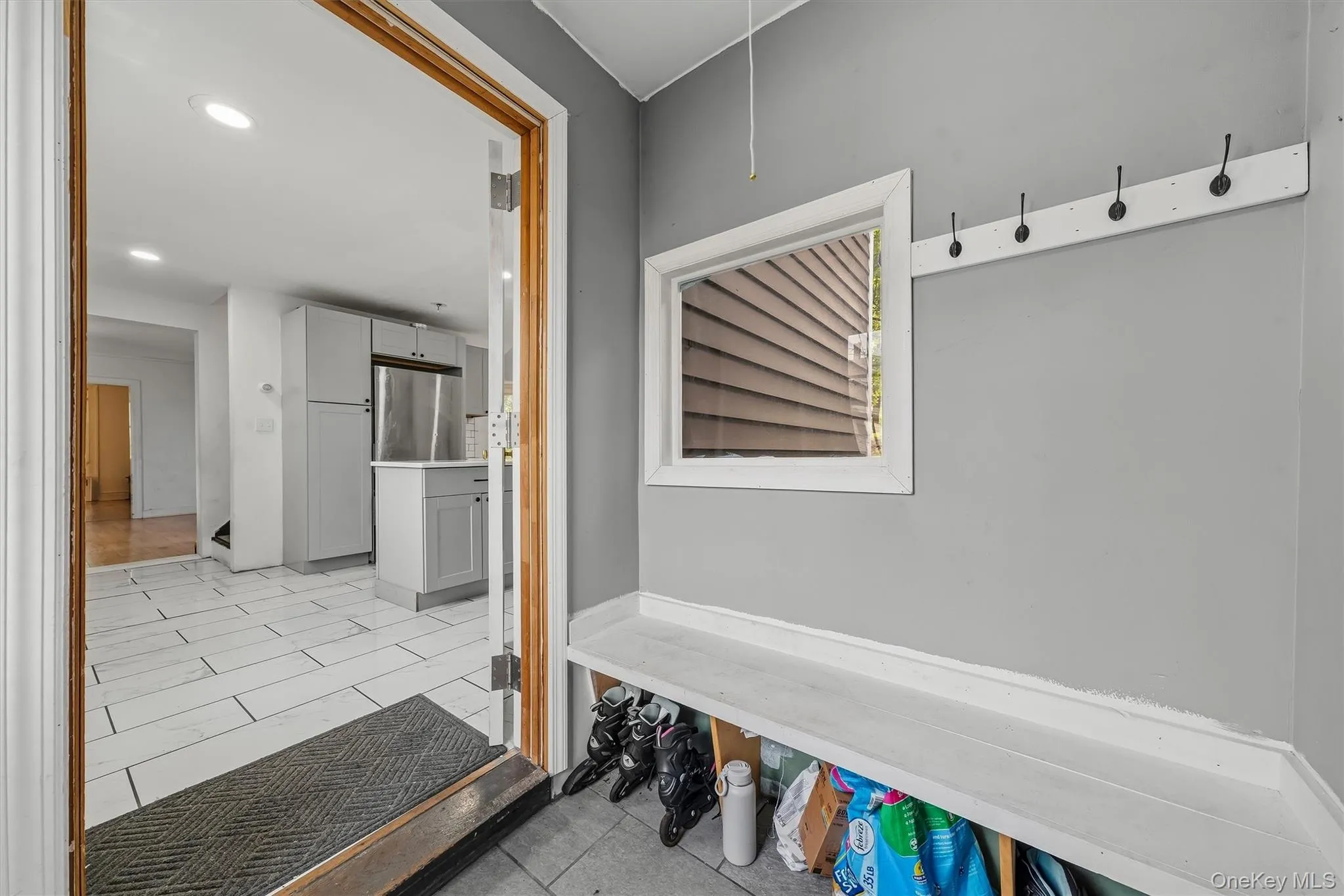Entryway featuring built-in bench seating, storage cubbies, and wall-mounted coat hooks Entryway featuring built-in bench seating, storage cubbies, and wall-mounted coat hooks