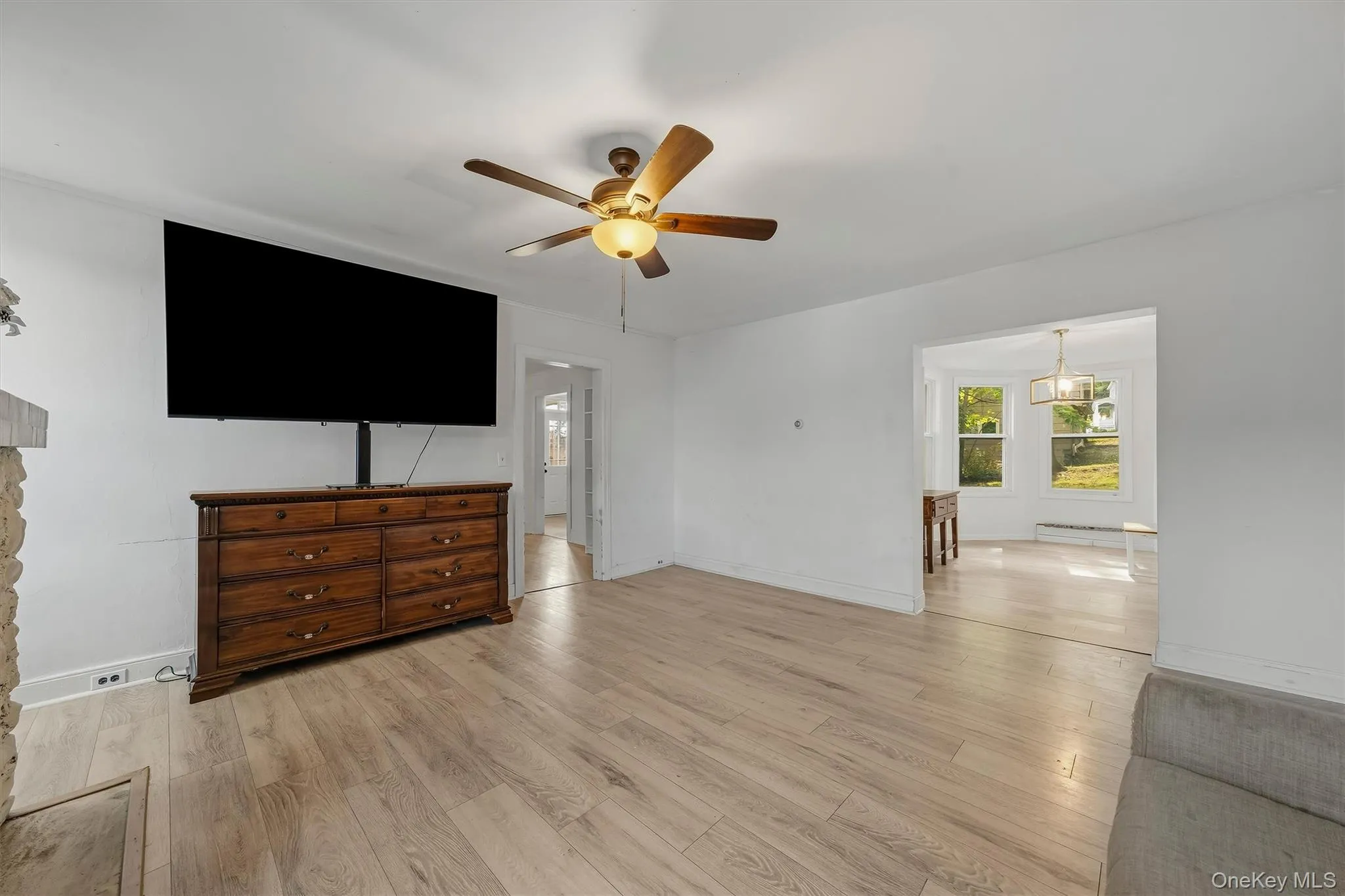 Light wood-finish flooring throughout, complemented by a ceiling fan with integrated lighting Light wood-finish flooring throughout, complemented by a ceiling fan with integrated lighting