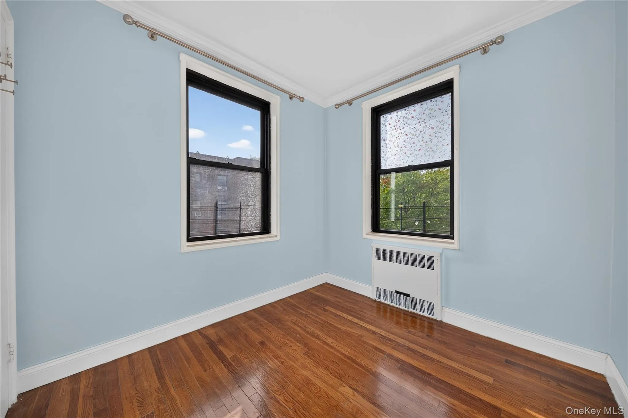 Hardwood flooring, painted walls, white trim, and two windows Hardwood flooring, painted walls, white trim, and two windows