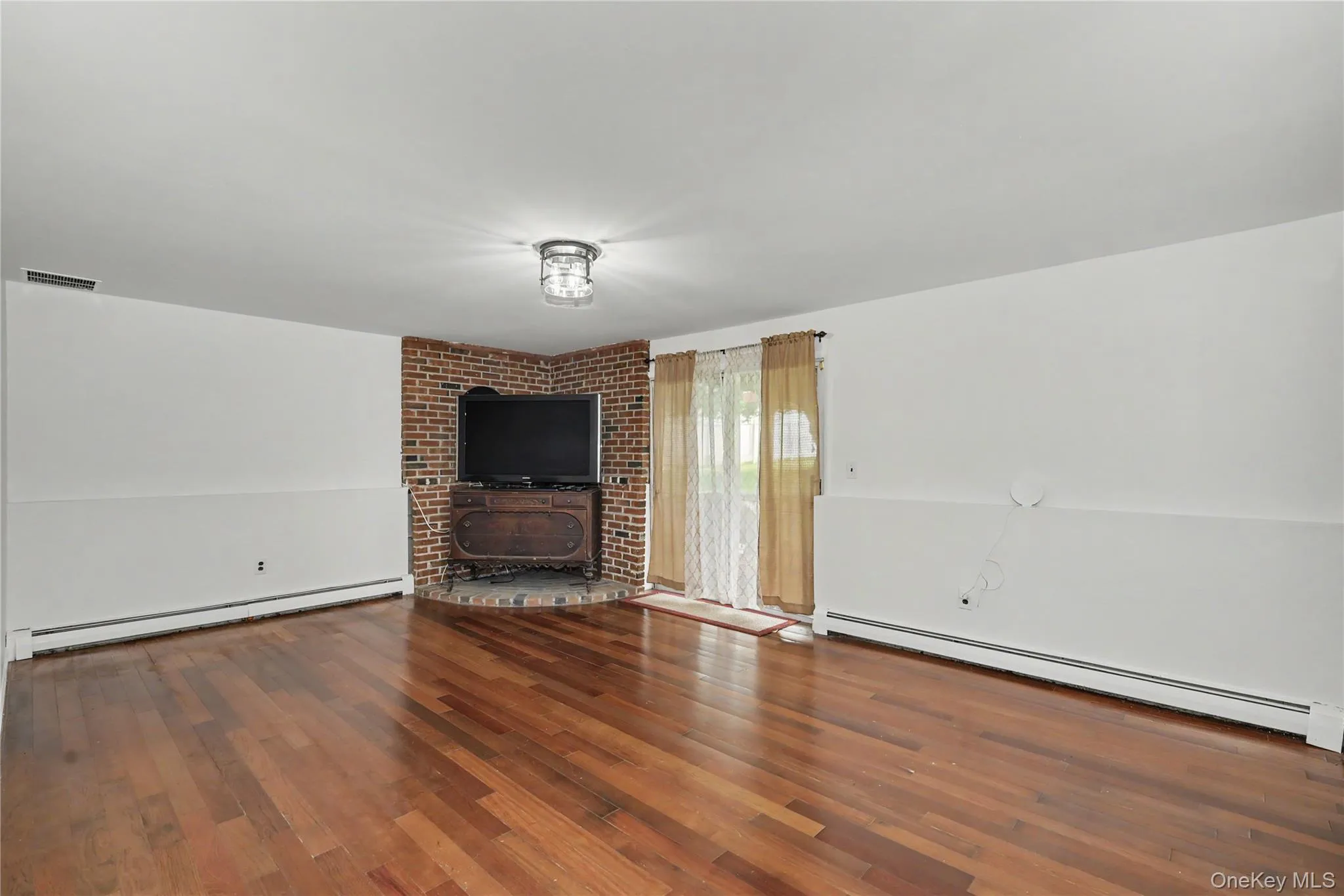 Huge family room with bricked platform for woodburning stove and glass sliders to backyard Huge family room with bricked platform for woodburning stove and glass sliders to backyard