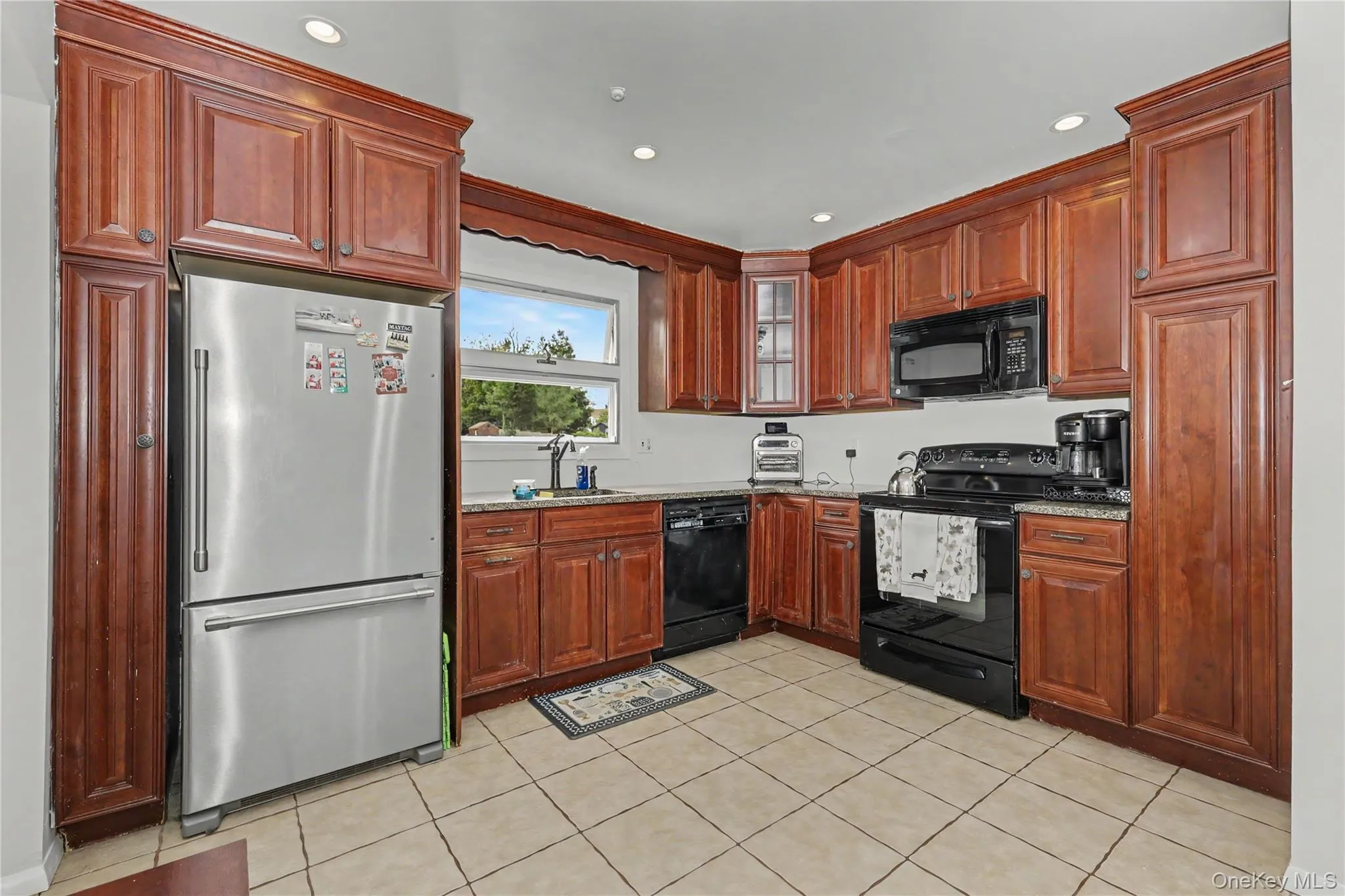 Well equipped and ample kitchen featuring wood cabinetry, recessed lighting, tile flooring and pantry Well equipped and ample kitchen featuring wood cabinetry, recessed lighting, tile flooring and pantry