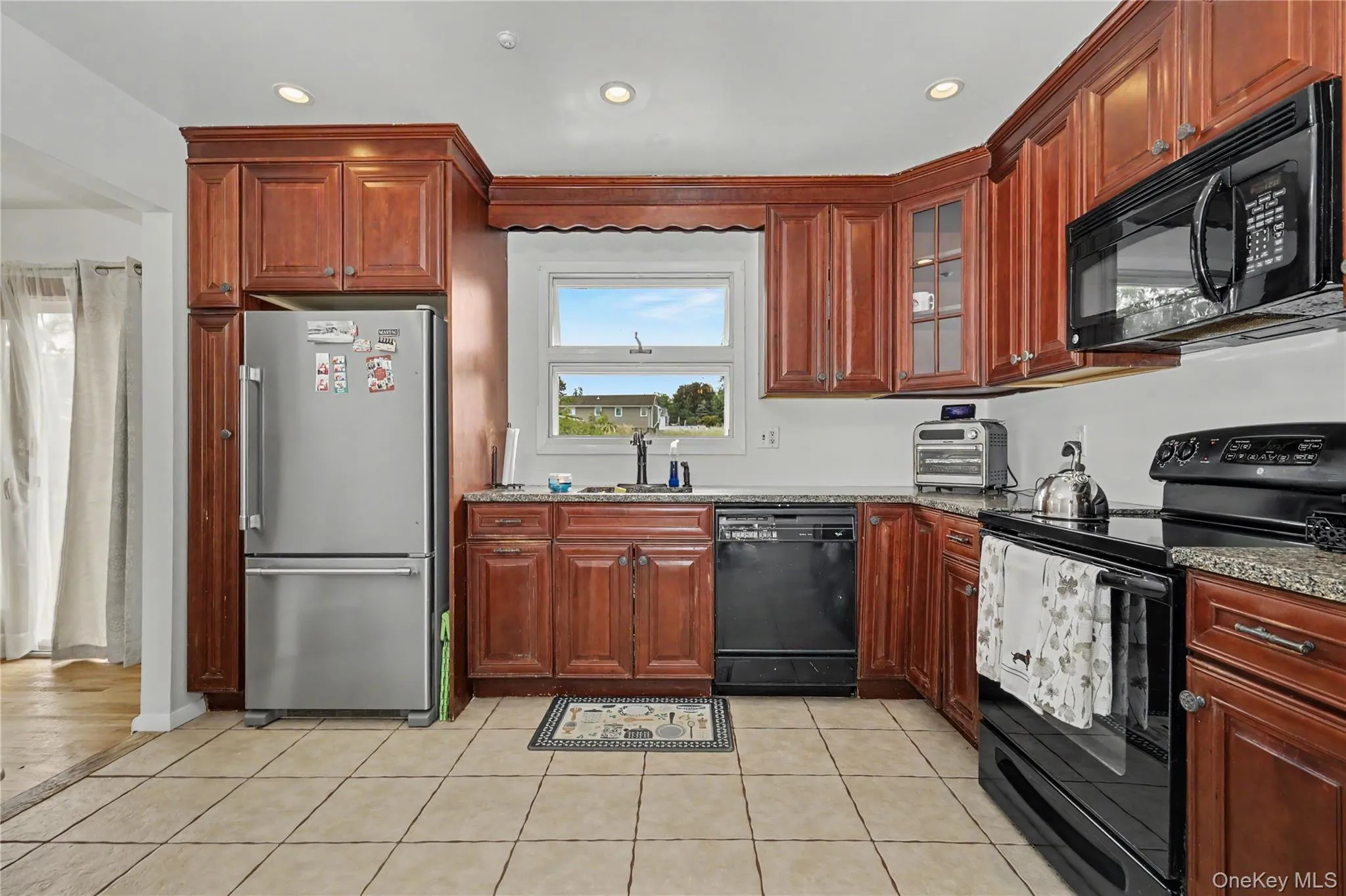 Well equipped and ample kitchen featuring wood cabinetry, recessed lighting, tile flooring and pantry Well equipped and ample kitchen featuring wood cabinetry, recessed lighting, tile flooring and pantry