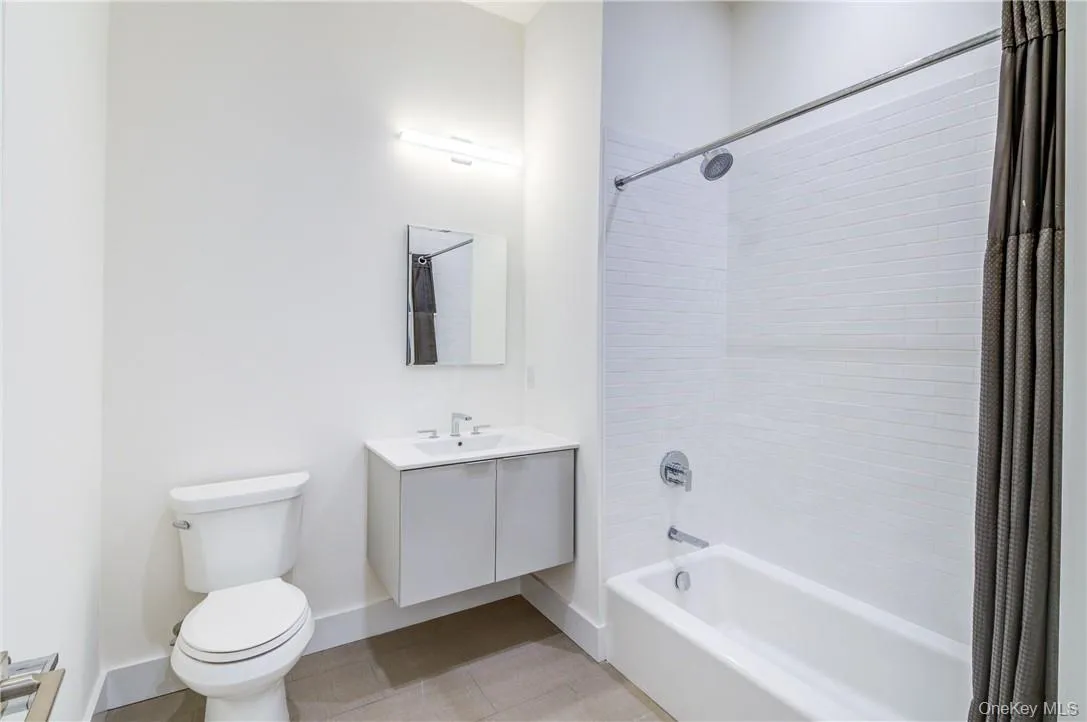Full bathroom featuring toilet, shower / tub combo, and vanity Full bathroom featuring toilet, shower / tub combo, and vanity