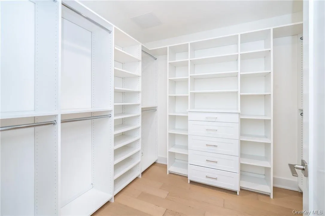 Spacious closet featuring light wood-type flooring Spacious closet featuring light wood-type flooring
