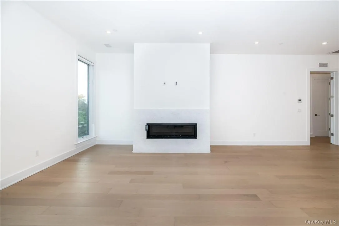 Unfurnished living room with light wood-type flooring Unfurnished living room with light wood-type flooring