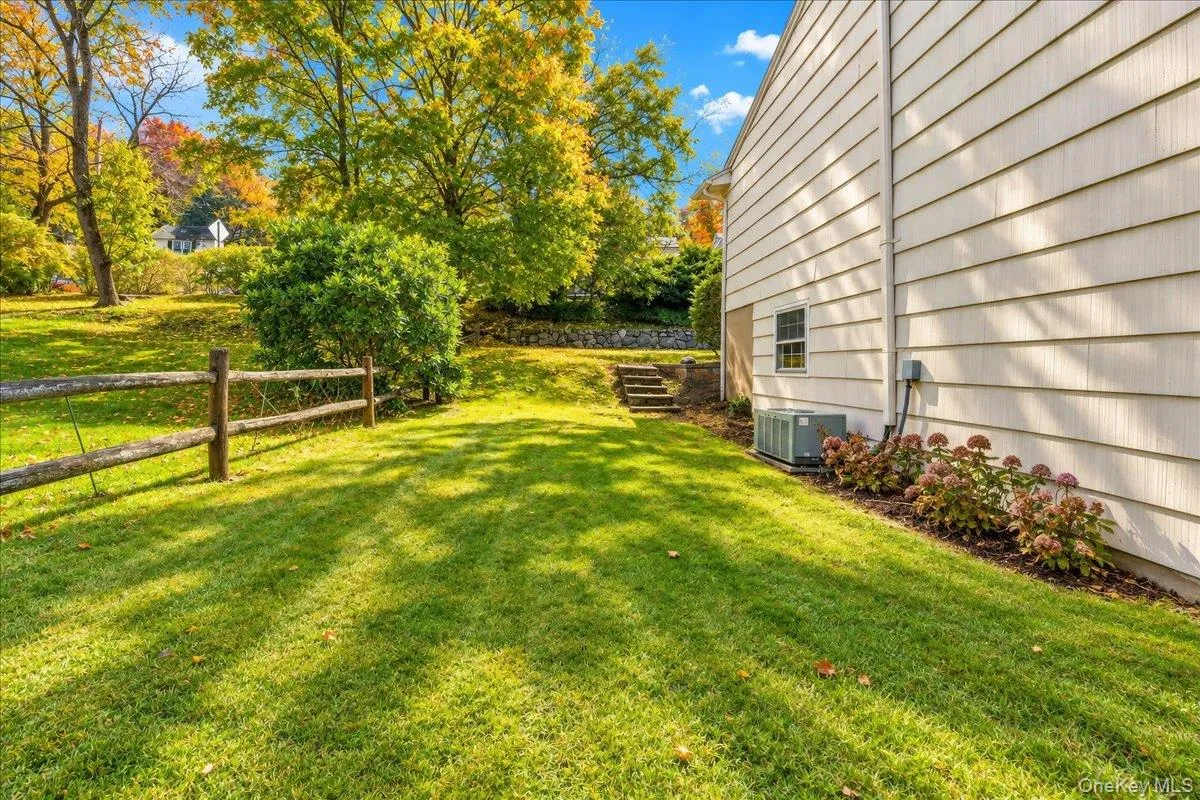Side yard with neatly maintained landscaping and a freshly painted exterior, offering a welcoming path to the front of the home. Side yard with neatly maintained landscaping and a freshly painted exterior, offering a welcoming path to the front of the home.