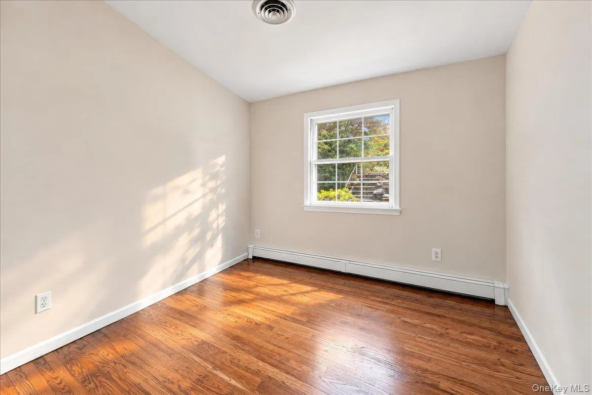 Bright and airy bedroom featuring newly refinished hardwood floors and fresh paint, creating a clean, welcoming feel. Bright and airy bedroom featuring newly refinished hardwood floors and fresh paint, creating a clean, welcoming feel.