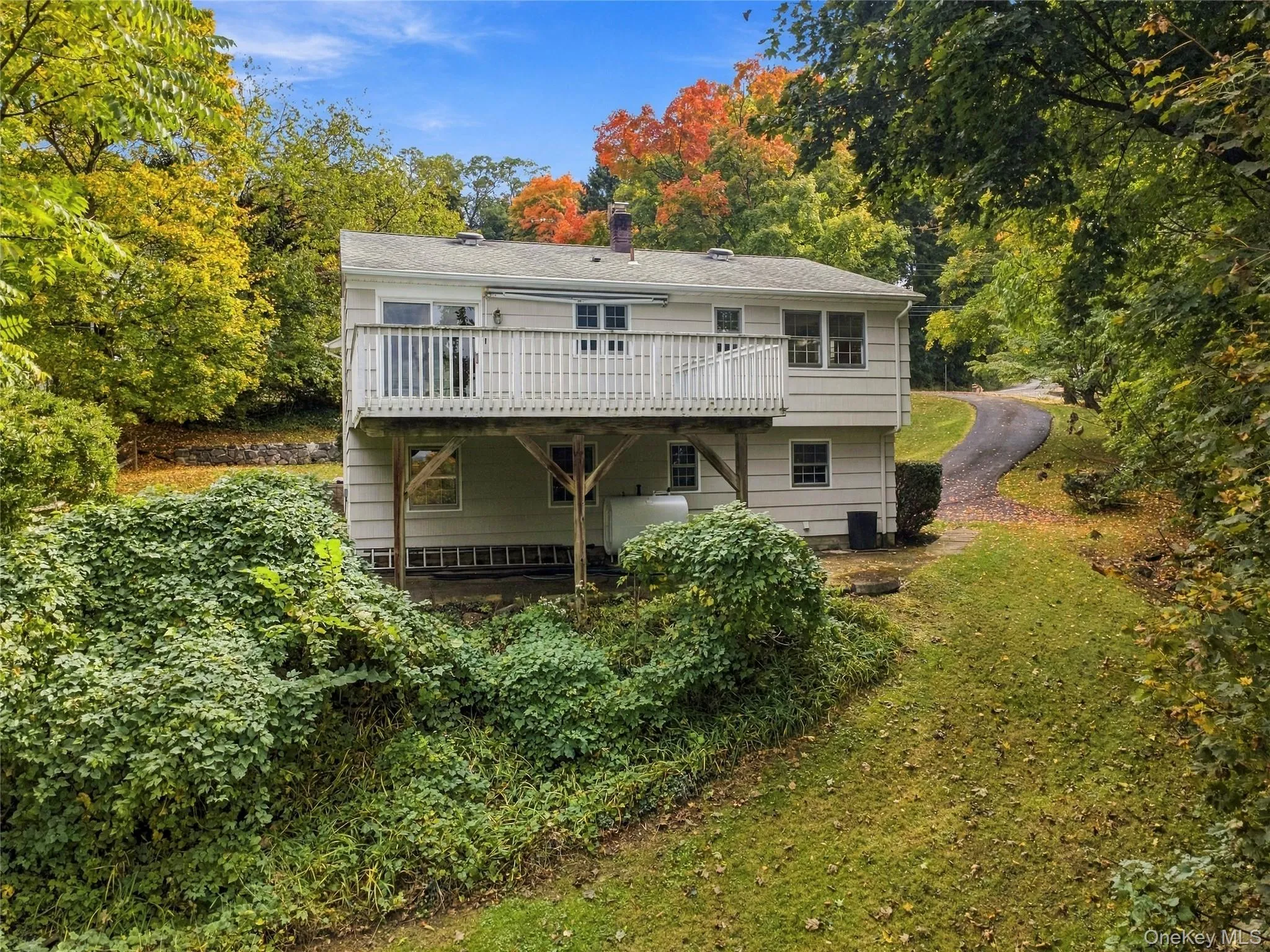 Rear view of the home showcasing the spacious deck, ideal for outdoor enjoyment and entertaining. Rear view of the home showcasing the spacious deck, ideal for outdoor enjoyment and entertaining.