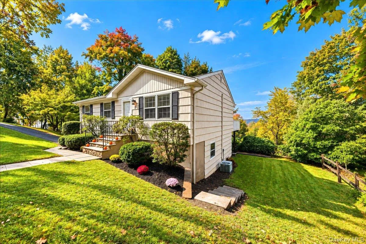 Side yard with neatly maintained landscaping and a freshly painted exterior, offering a welcoming path around to the back of the home. Side yard with neatly maintained landscaping and a freshly painted exterior, offering a welcoming path around to the back of the home.