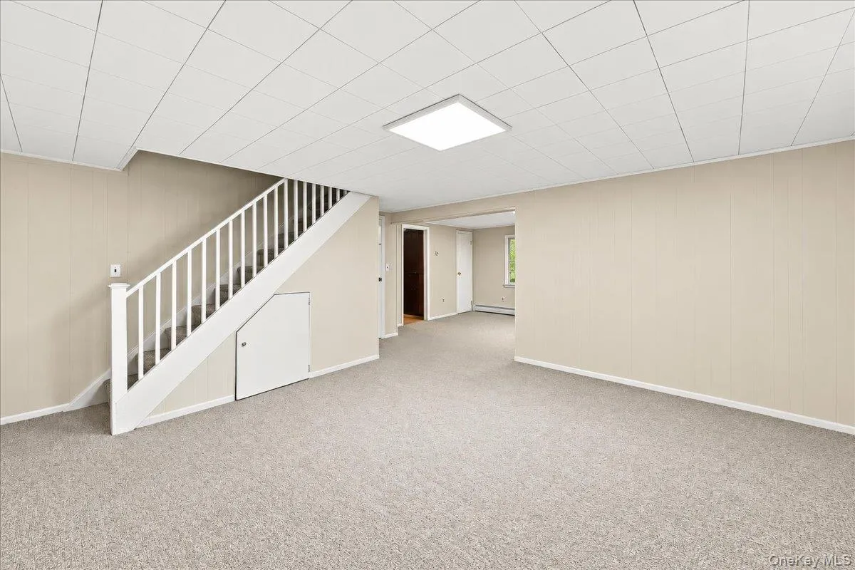 Spacious lower-level family room with a partial view of the adjoining recreation area, offering flexible space for a home office, home gym, hobby room, or play area. Spacious lower-level family room with a partial view of the adjoining recreation area, offering flexible space for a home office, home gym, hobby room, or play area.