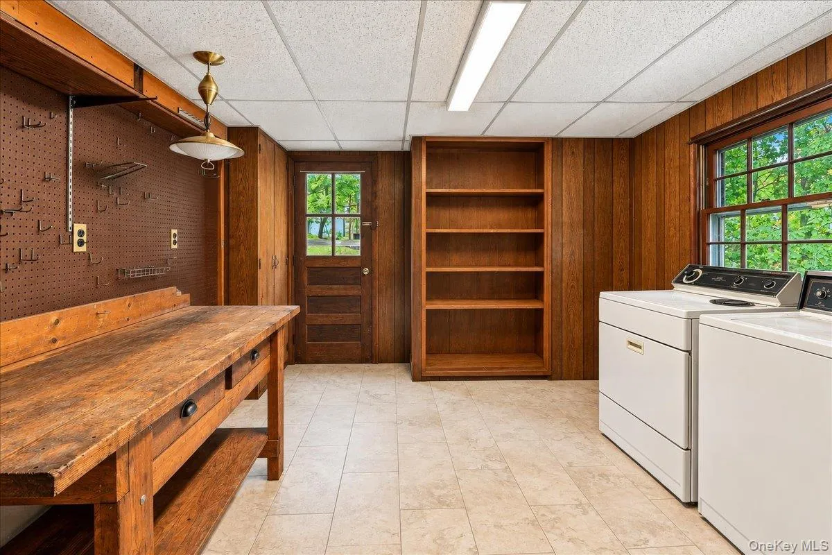 Functional utility room featuring a washer and dryer, workbench, and ample storage, with convenient direct access to the driveway. Functional utility room featuring a washer and dryer, workbench, and ample storage, with convenient direct access to the driveway.