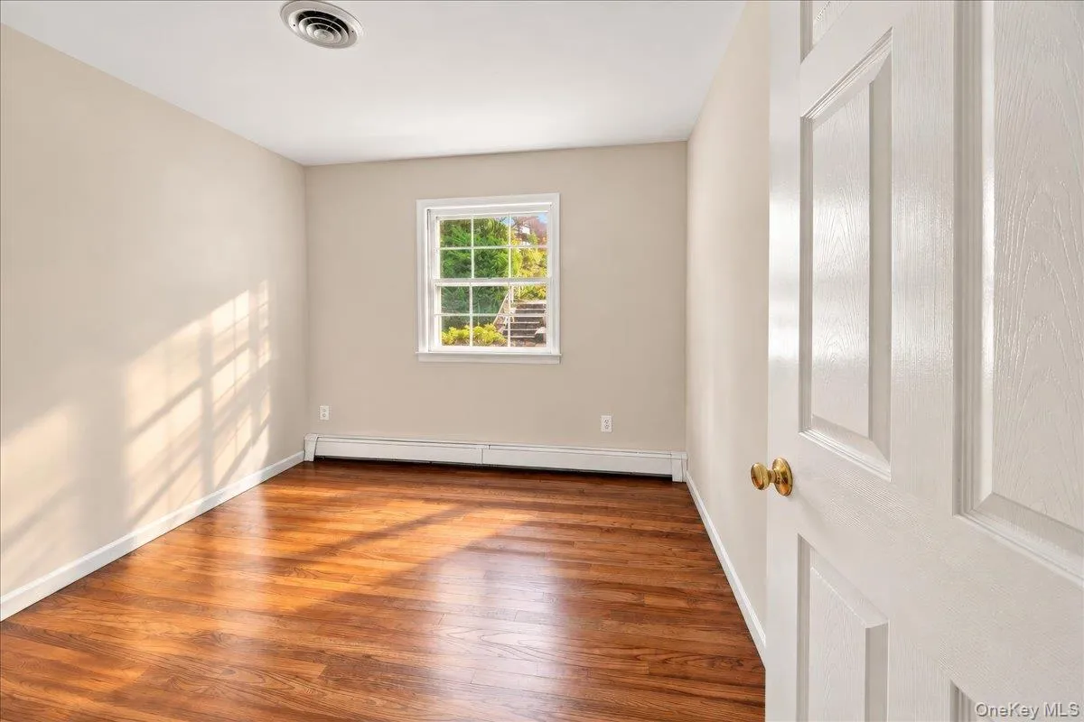 Bright and airy bedroom featuring newly refinished hardwood floors and fresh paint, creating a clean, welcoming feel. Bright and airy bedroom featuring newly refinished hardwood floors and fresh paint, creating a clean, welcoming feel.