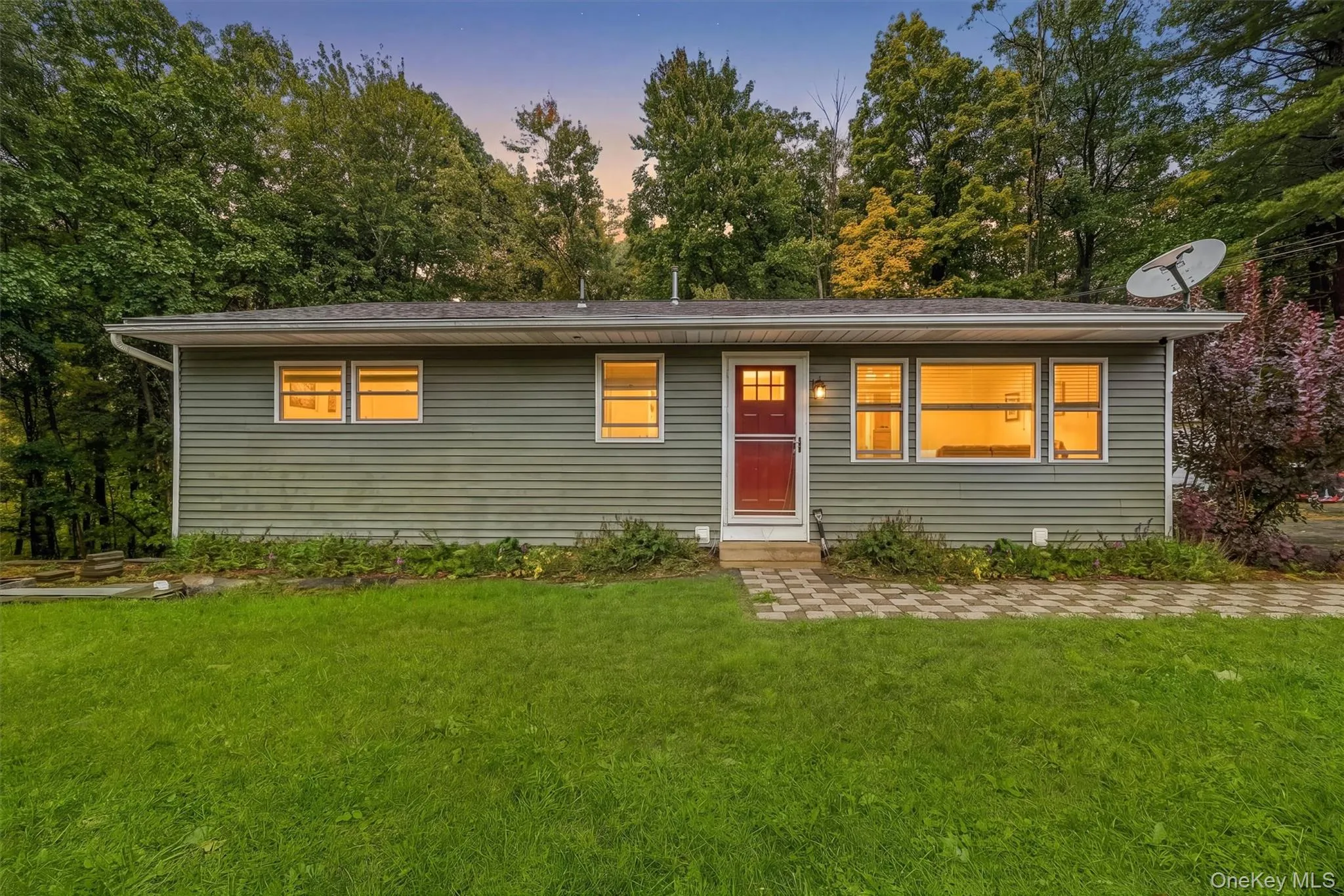 Single-story residence featuring horizontal siding, a red entry door, and multiple windows Single-story residence featuring horizontal siding, a red entry door, and multiple windows
