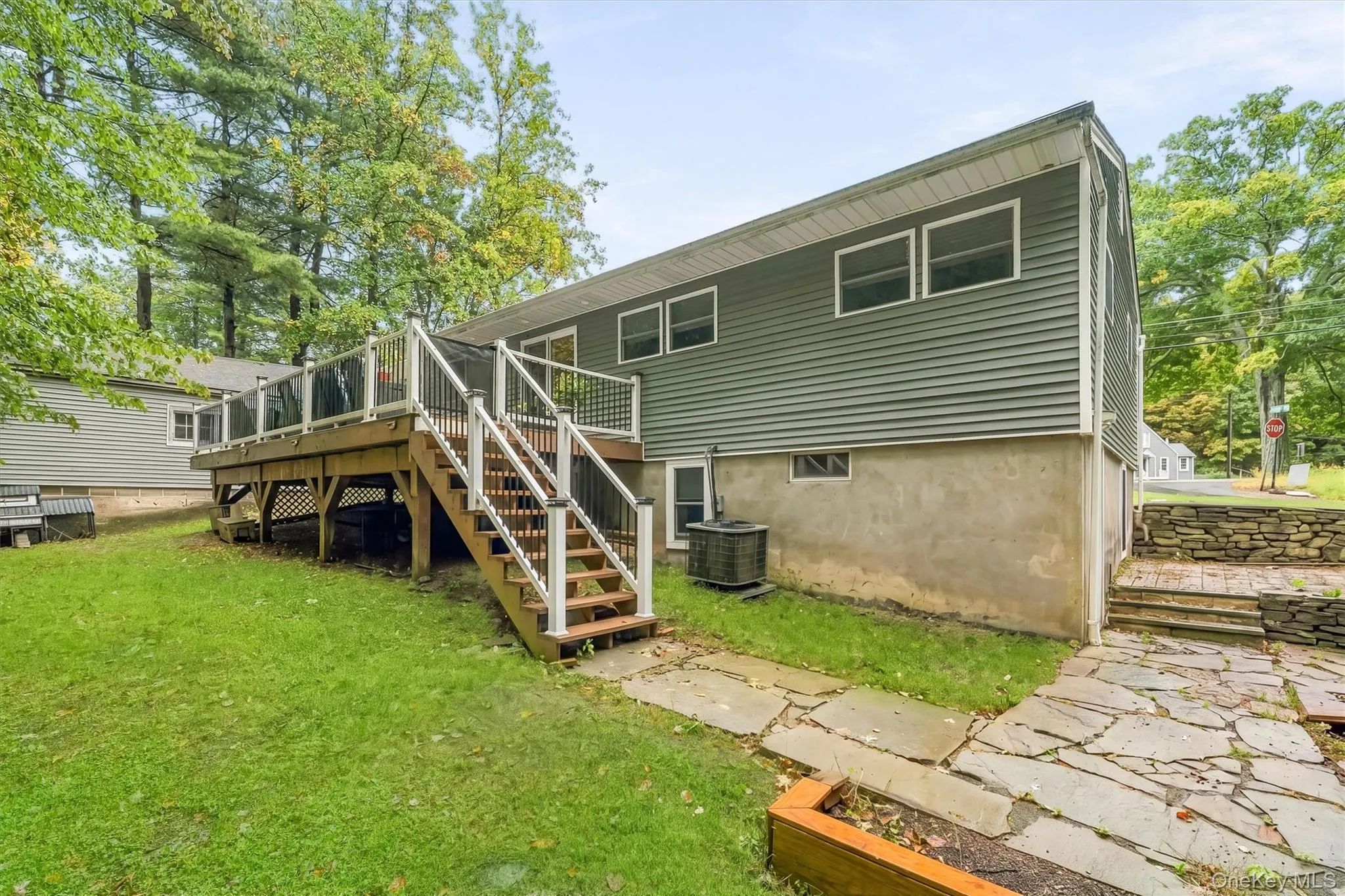 Expansive rear deck with glass panel railing and integrated staircase Expansive rear deck with glass panel railing and integrated staircase