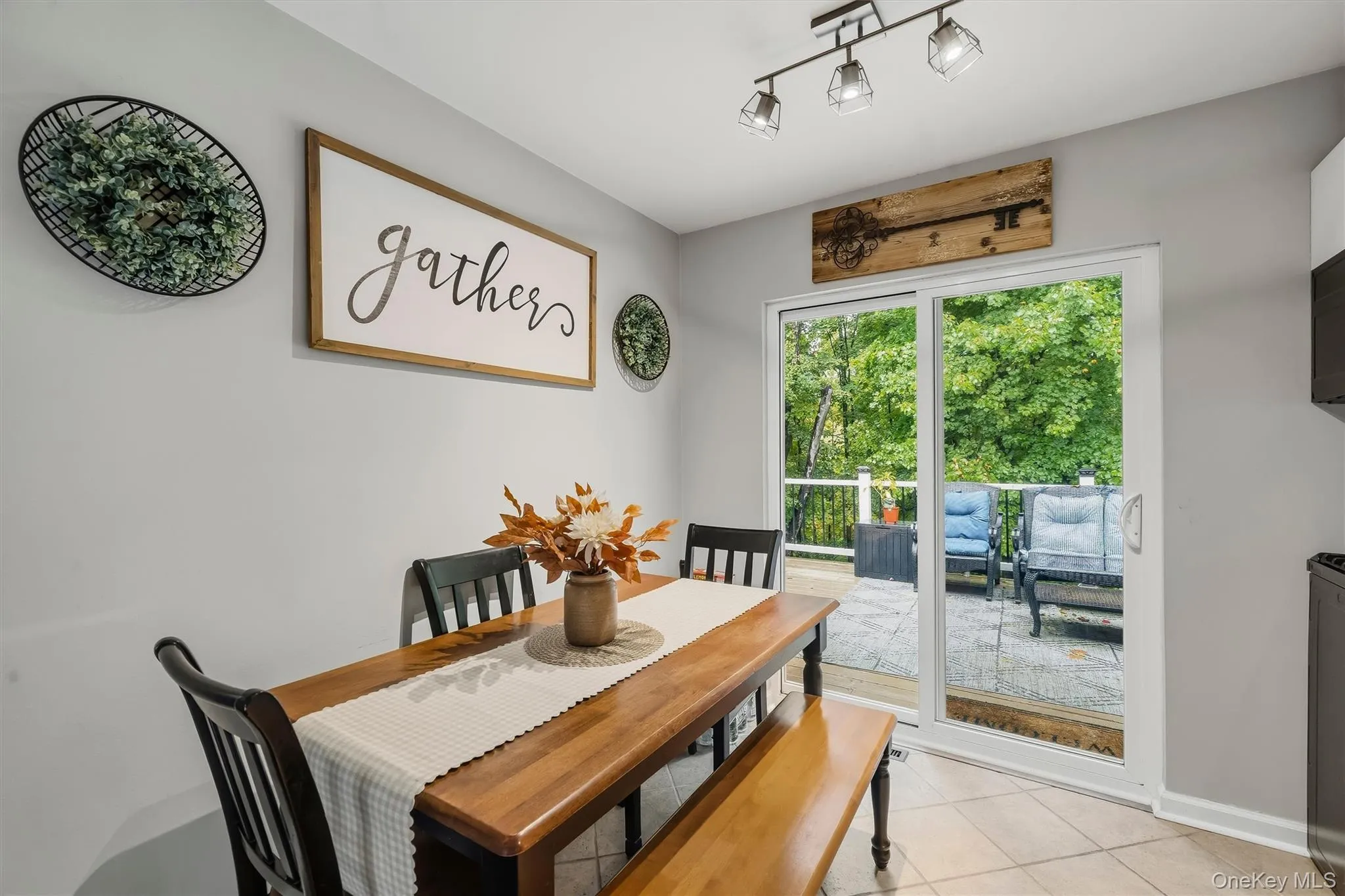 Sliding glass door leading to an outdoor deck, recessed track lighting, and tile flooring Sliding glass door leading to an outdoor deck, recessed track lighting, and tile flooring