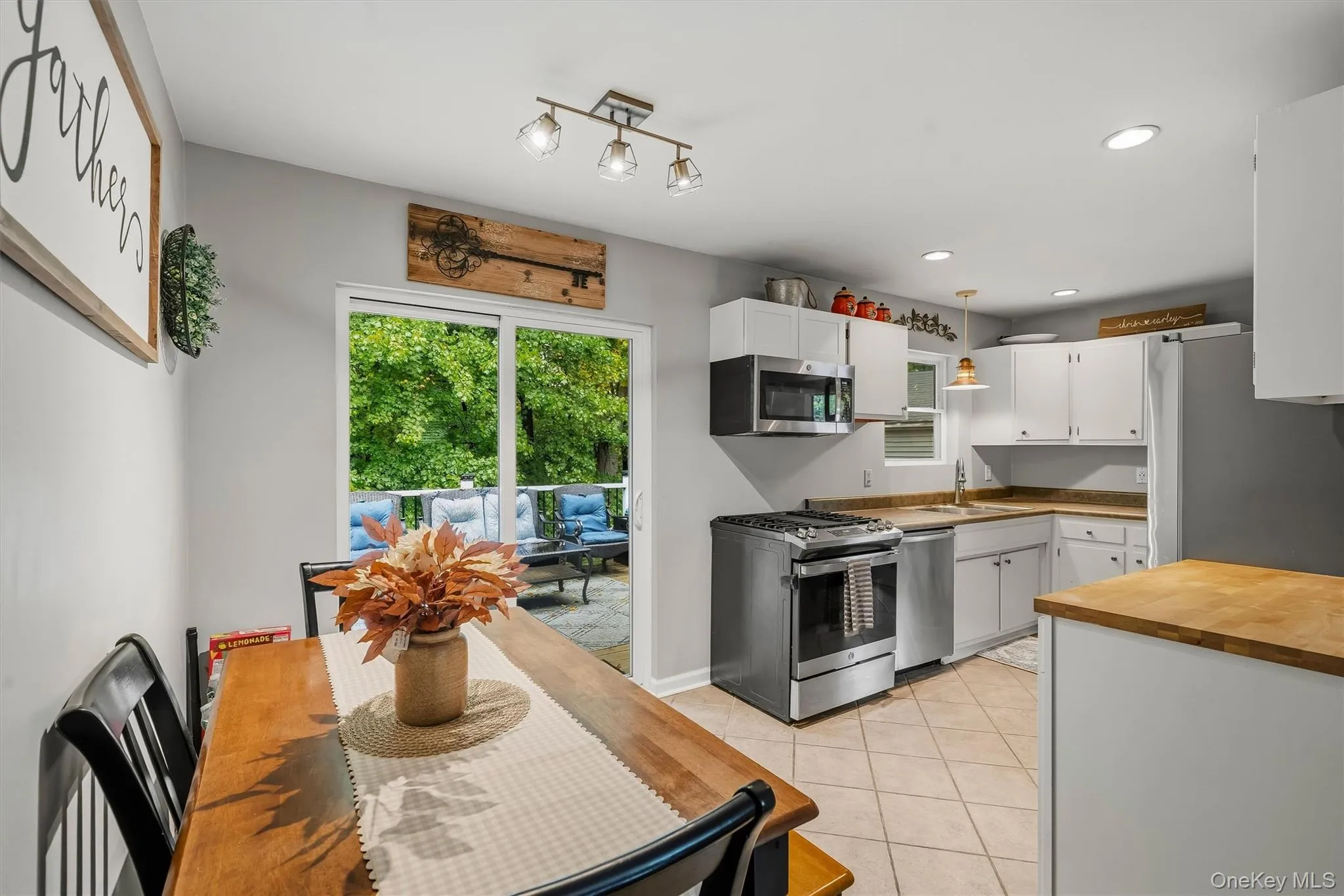 Kitchen featuring white cabinetry, stainless steel appliances, and a tile floor Kitchen featuring white cabinetry, stainless steel appliances, and a tile floor