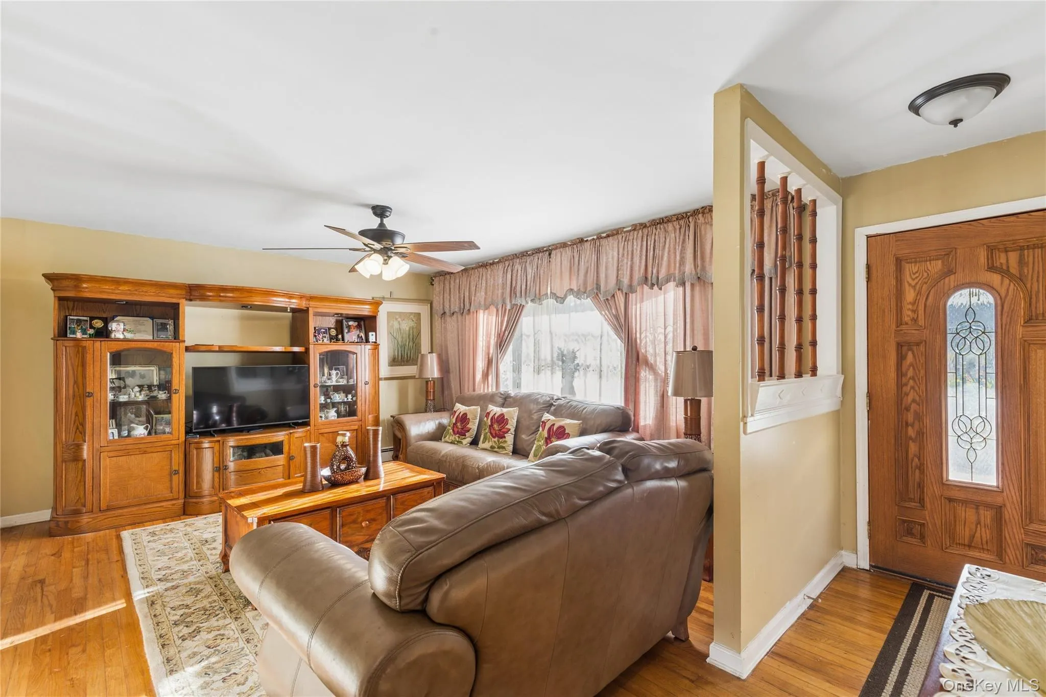 Hardwood flooring, ceiling fan, and decorative wood entry door with leaded glass insert Hardwood flooring, ceiling fan, and decorative wood entry door with leaded glass insert