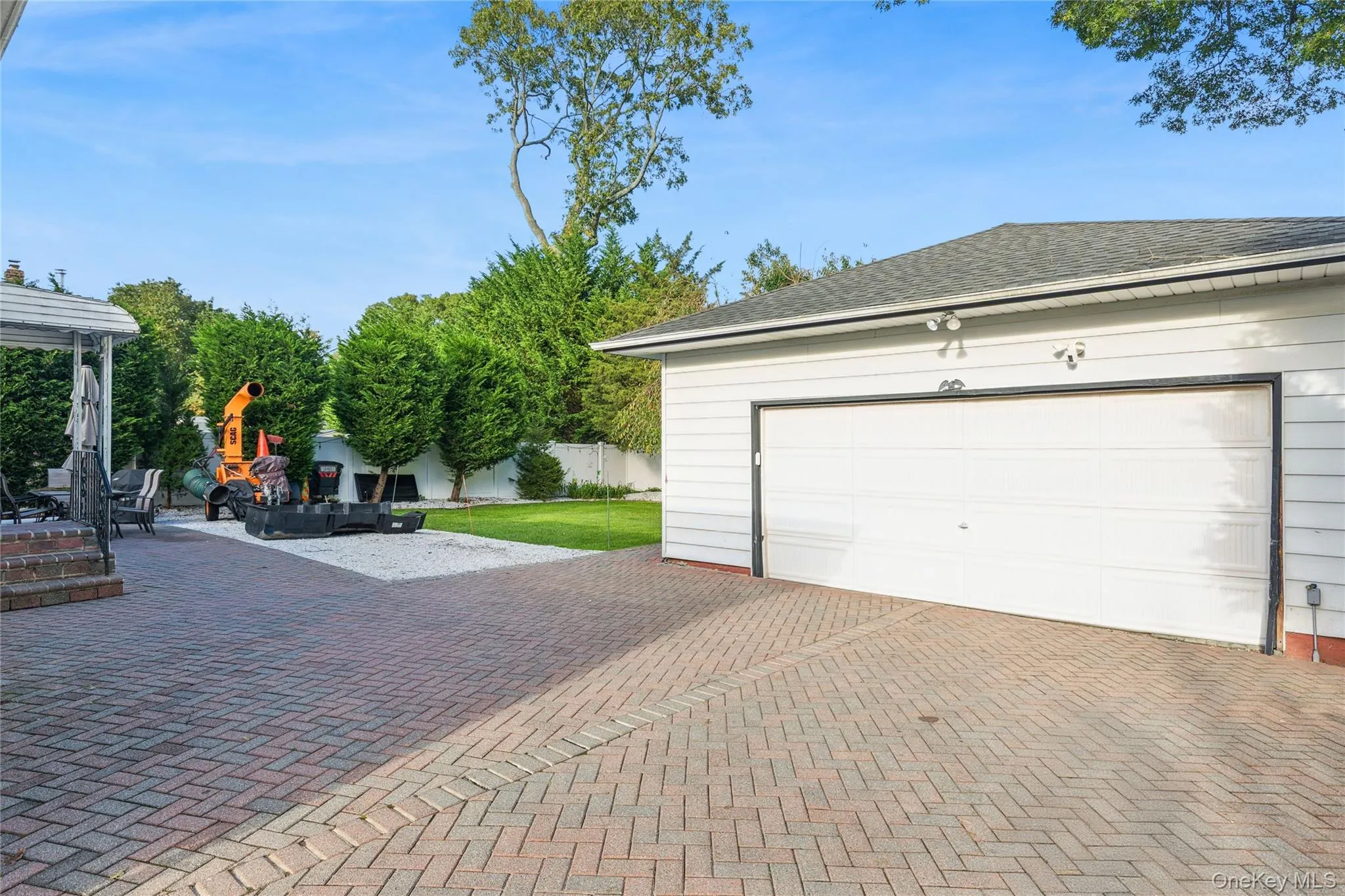 Detached garage with horizontal siding, a 2 car large white garage door, and exterior lighting Detached garage with horizontal siding, a 2 car large white garage door, and exterior lighting