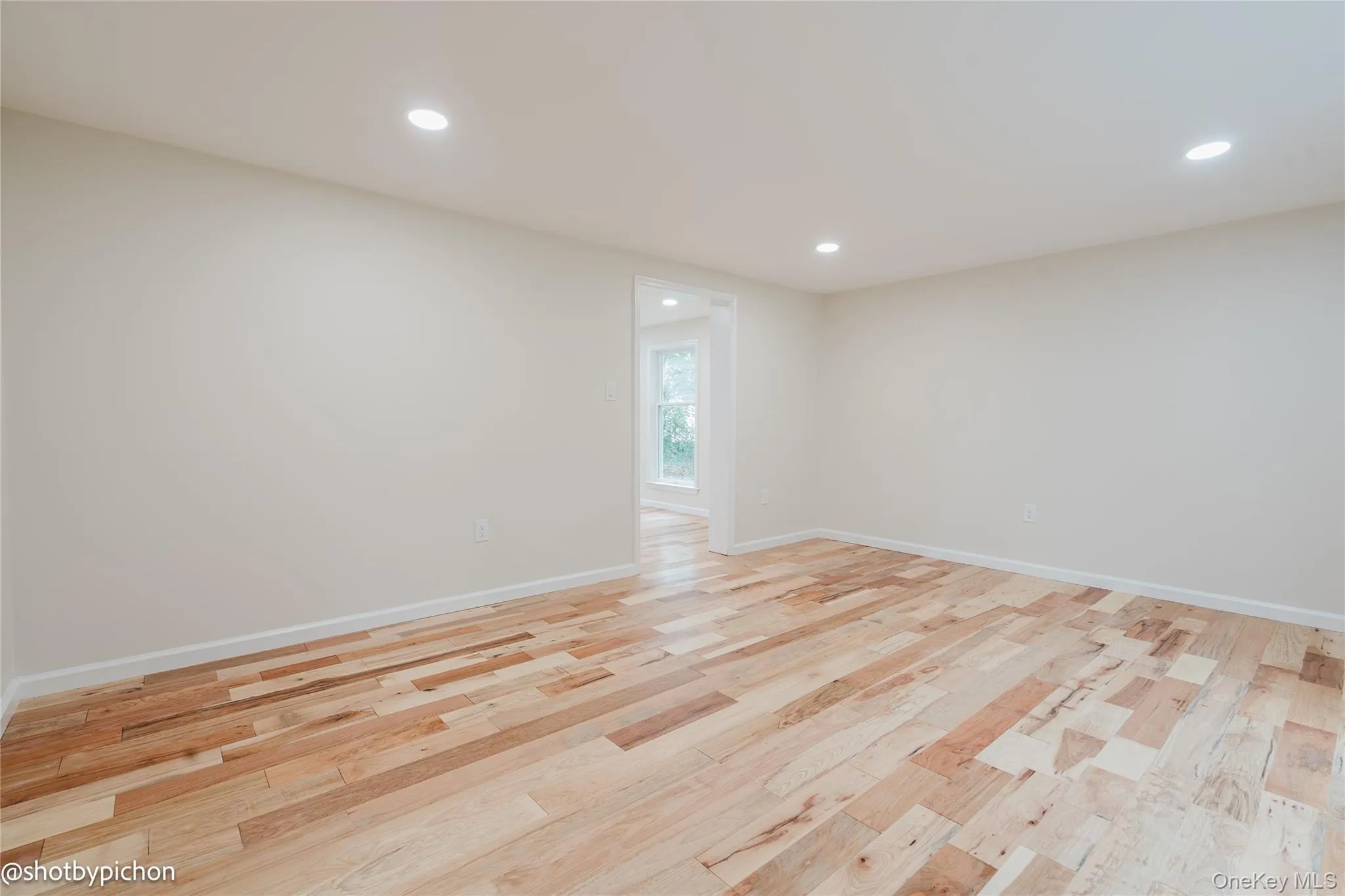 Recessed lighting, light wood-finish flooring, white walls, and a doorway opening to another room Recessed lighting, light wood-finish flooring, white walls, and a doorway opening to another room