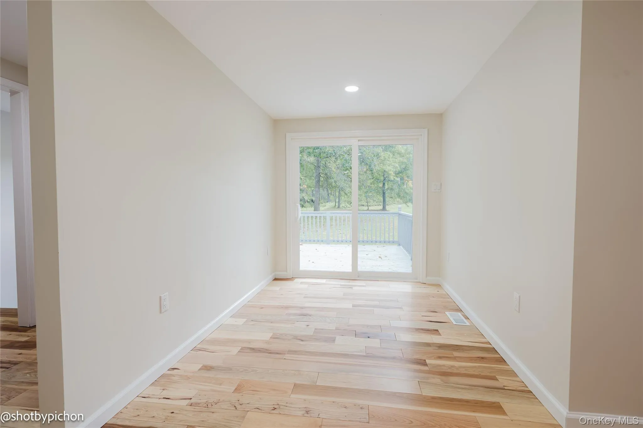 Wood-finish flooring, recessed ceiling light, sliding glass door to an outdoor deck Wood-finish flooring, recessed ceiling light, sliding glass door to an outdoor deck