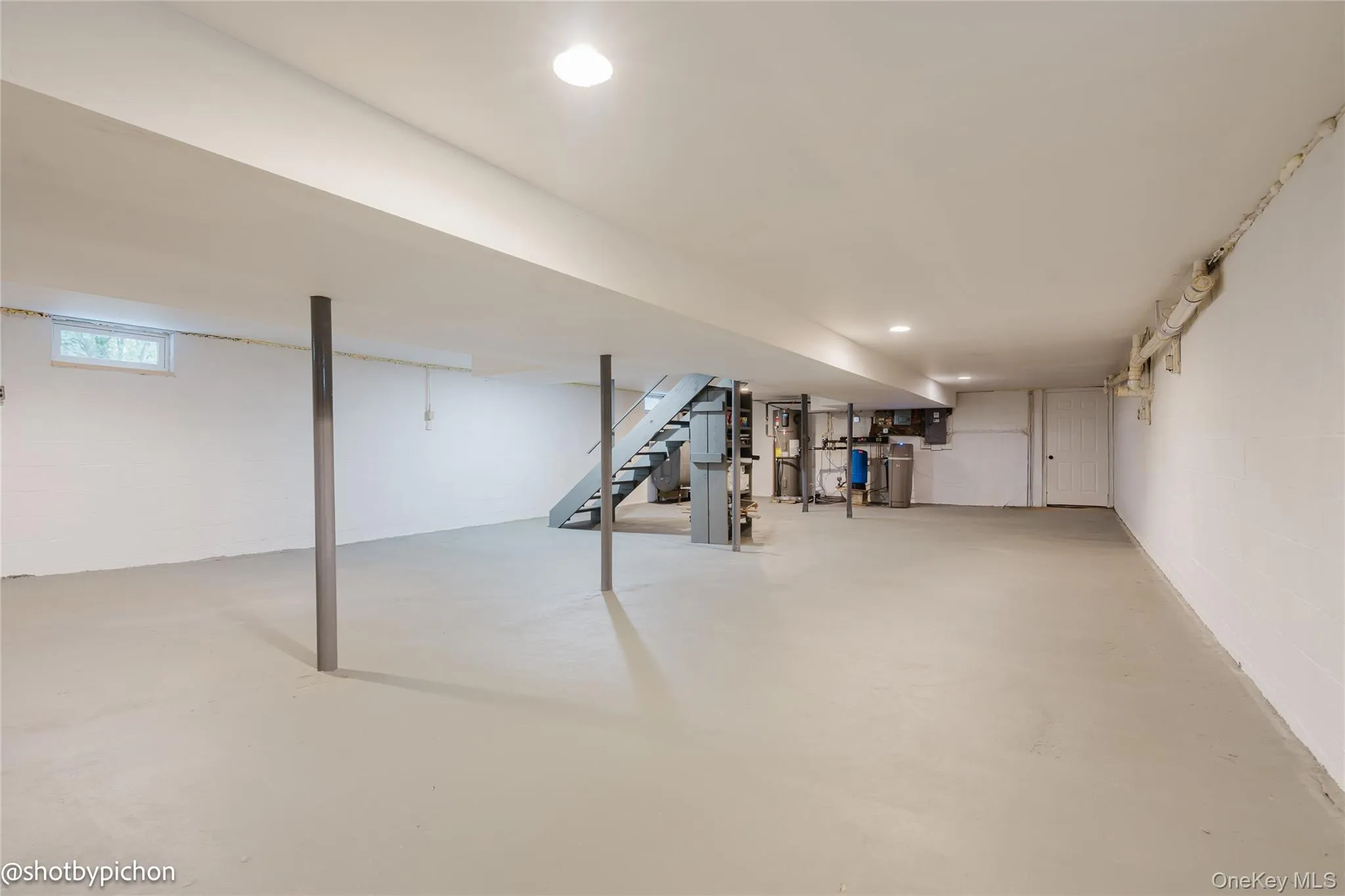 Expansive lower level with painted concrete flooring, recessed lighting, and a utility area Expansive lower level with painted concrete flooring, recessed lighting, and a utility area