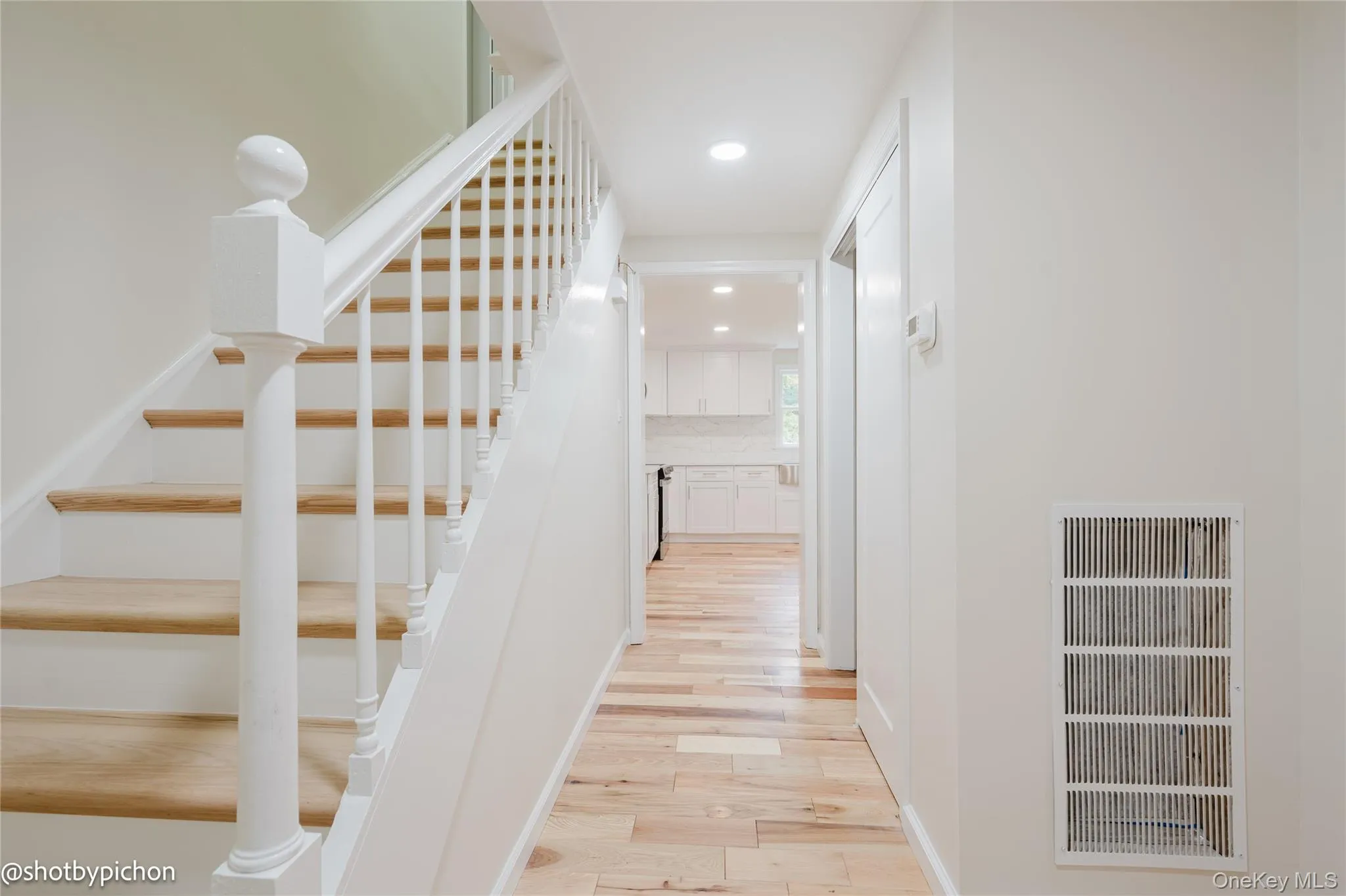 Hardwood flooring, painted white staircase with wood treads, recessed lighting, and white interior doors Hardwood flooring, painted white staircase with wood treads, recessed lighting, and white interior doors