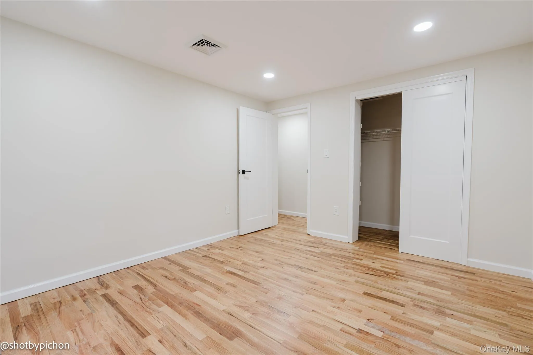 Recessed lighting illuminates the wood-finish flooring Recessed lighting illuminates the wood-finish flooring