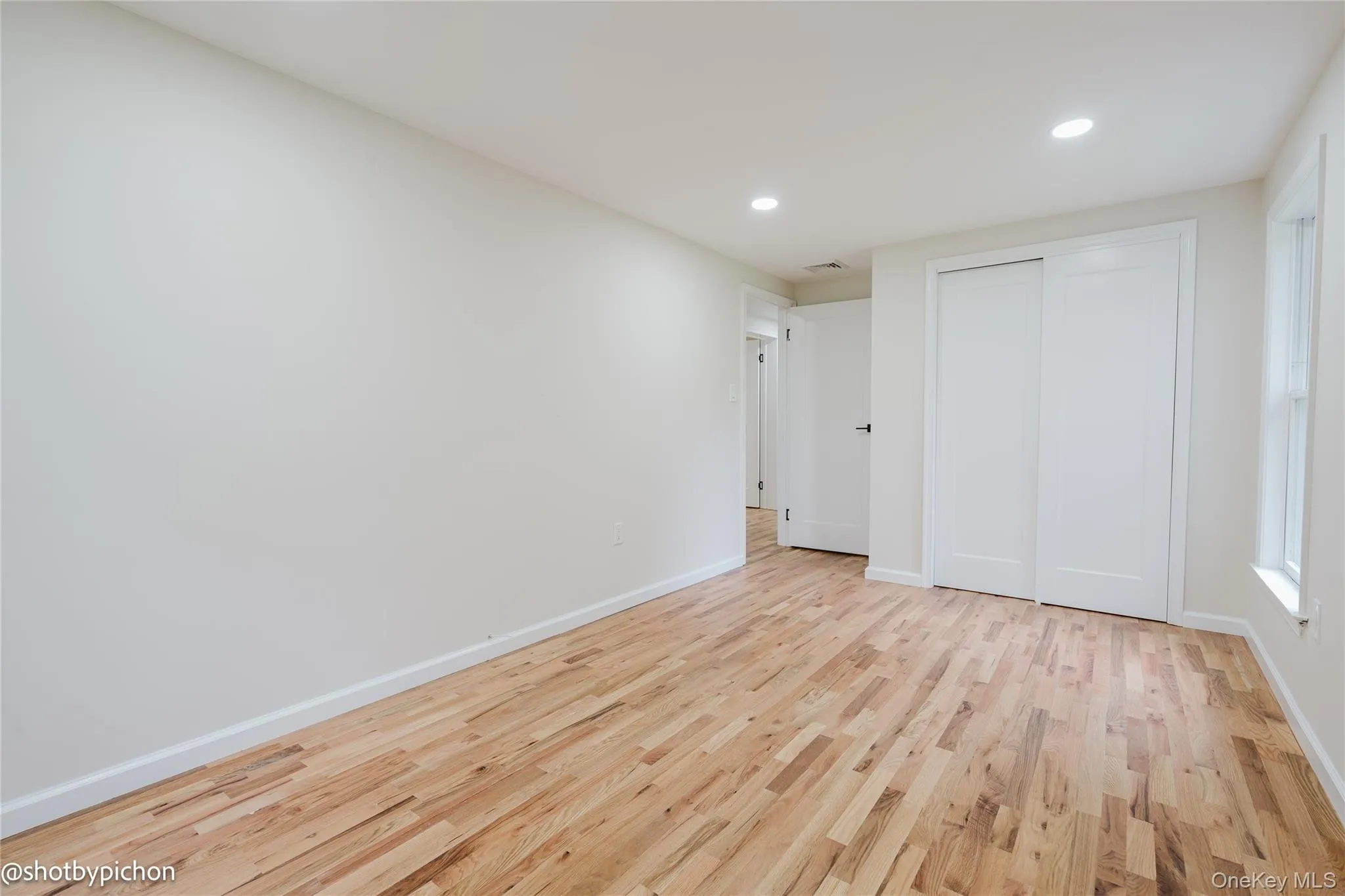 Hardwood flooring, recessed lighting, white walls, and white trim Hardwood flooring, recessed lighting, white walls, and white trim