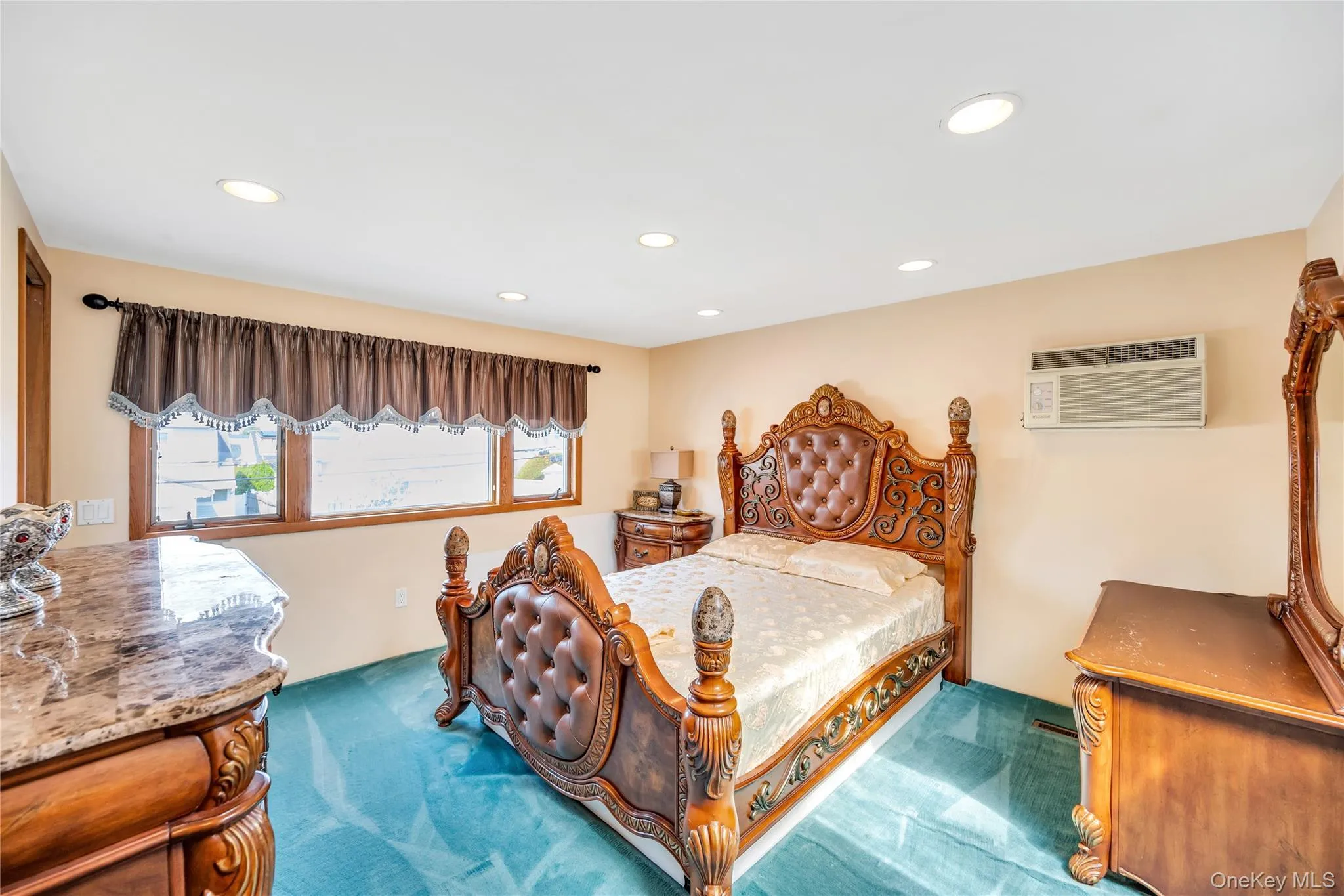Carpeted bedroom with recessed lighting and an AC wall unit Carpeted bedroom with recessed lighting and an AC wall unit
