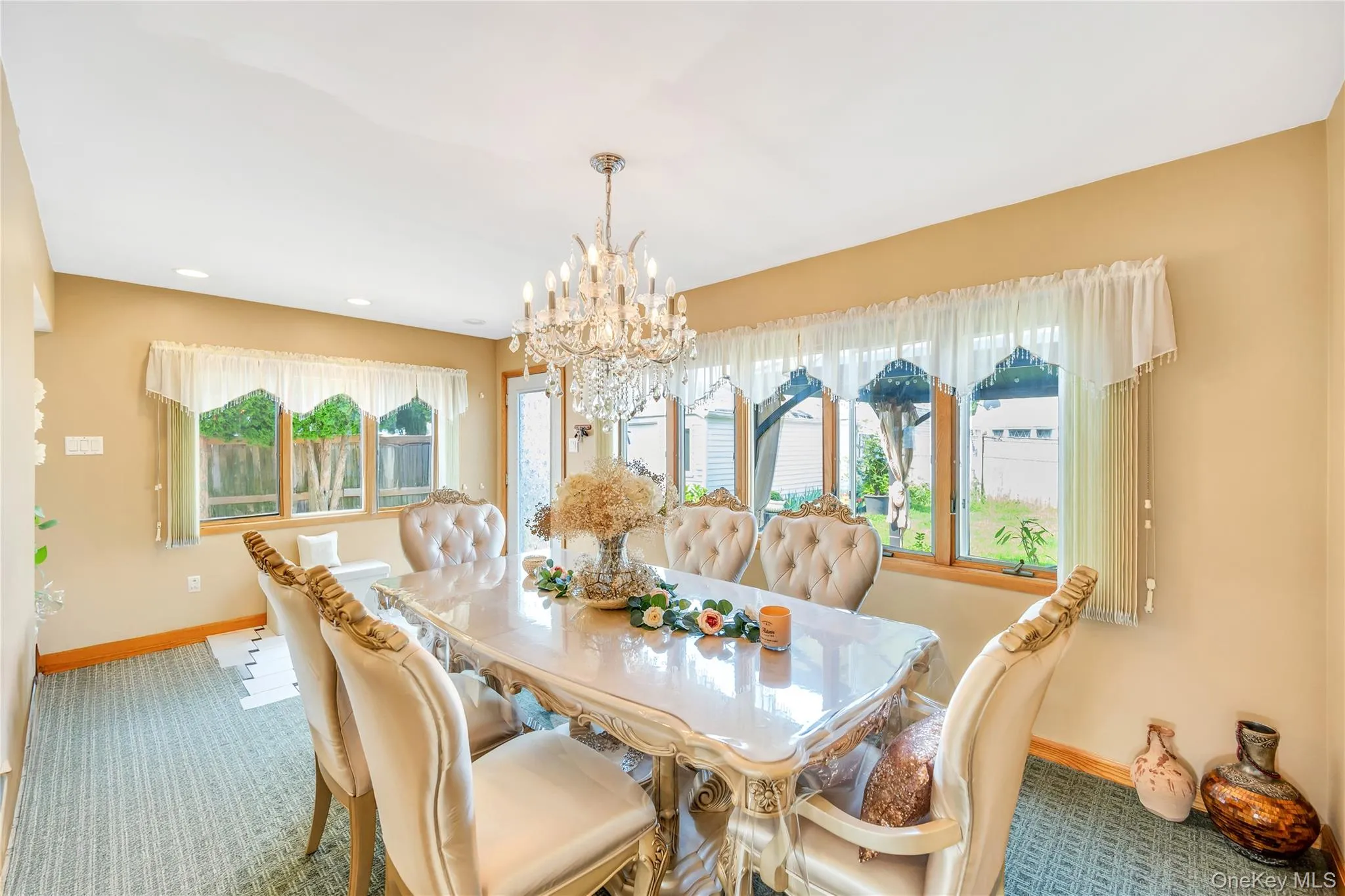 Carpeted dining area with a chandelier and recessed lighting Carpeted dining area with a chandelier and recessed lighting