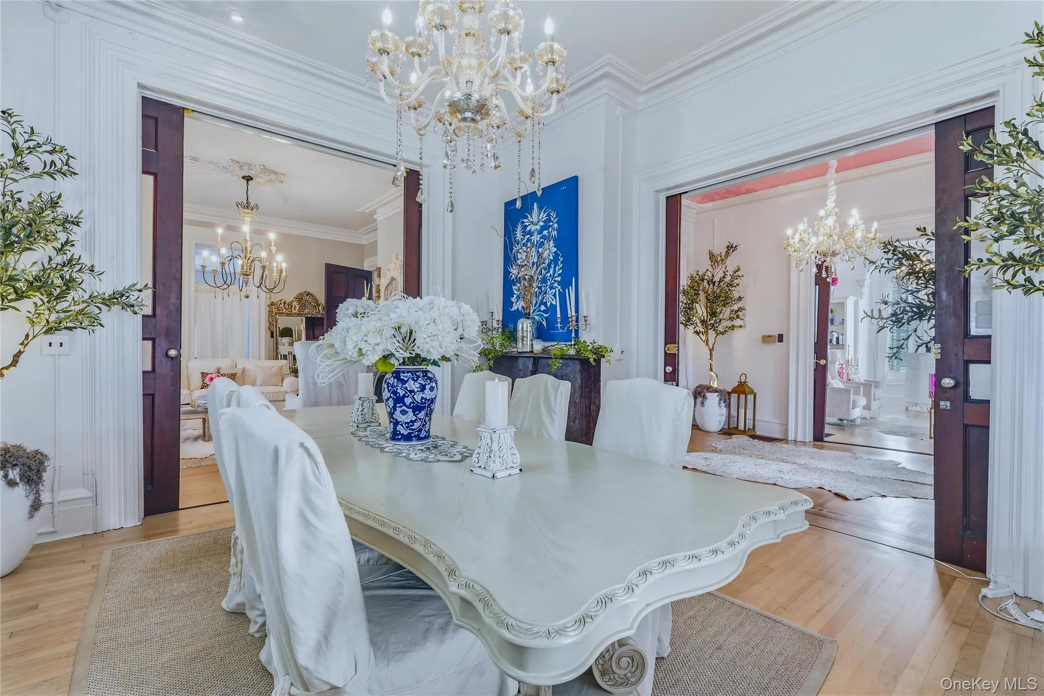 Ornate chandelier, decorative crown molding, light wood-finish flooring, and pocket doors Ornate chandelier, decorative crown molding, light wood-finish flooring, and pocket doors