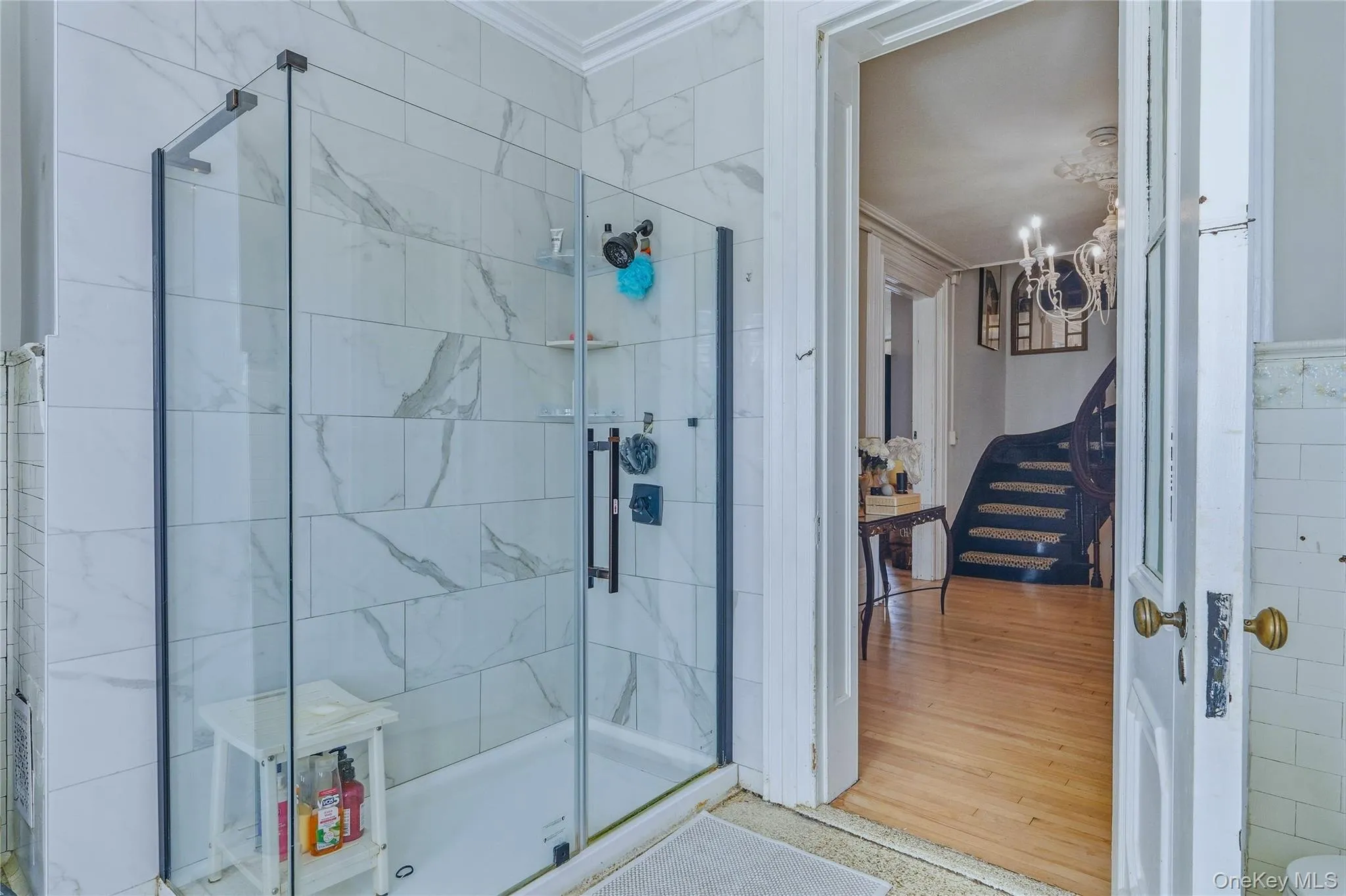 Glass-enclosed shower with subway tile surround, matte black shower fixtures, and integrated shelving Glass-enclosed shower with subway tile surround, matte black shower fixtures, and integrated shelving