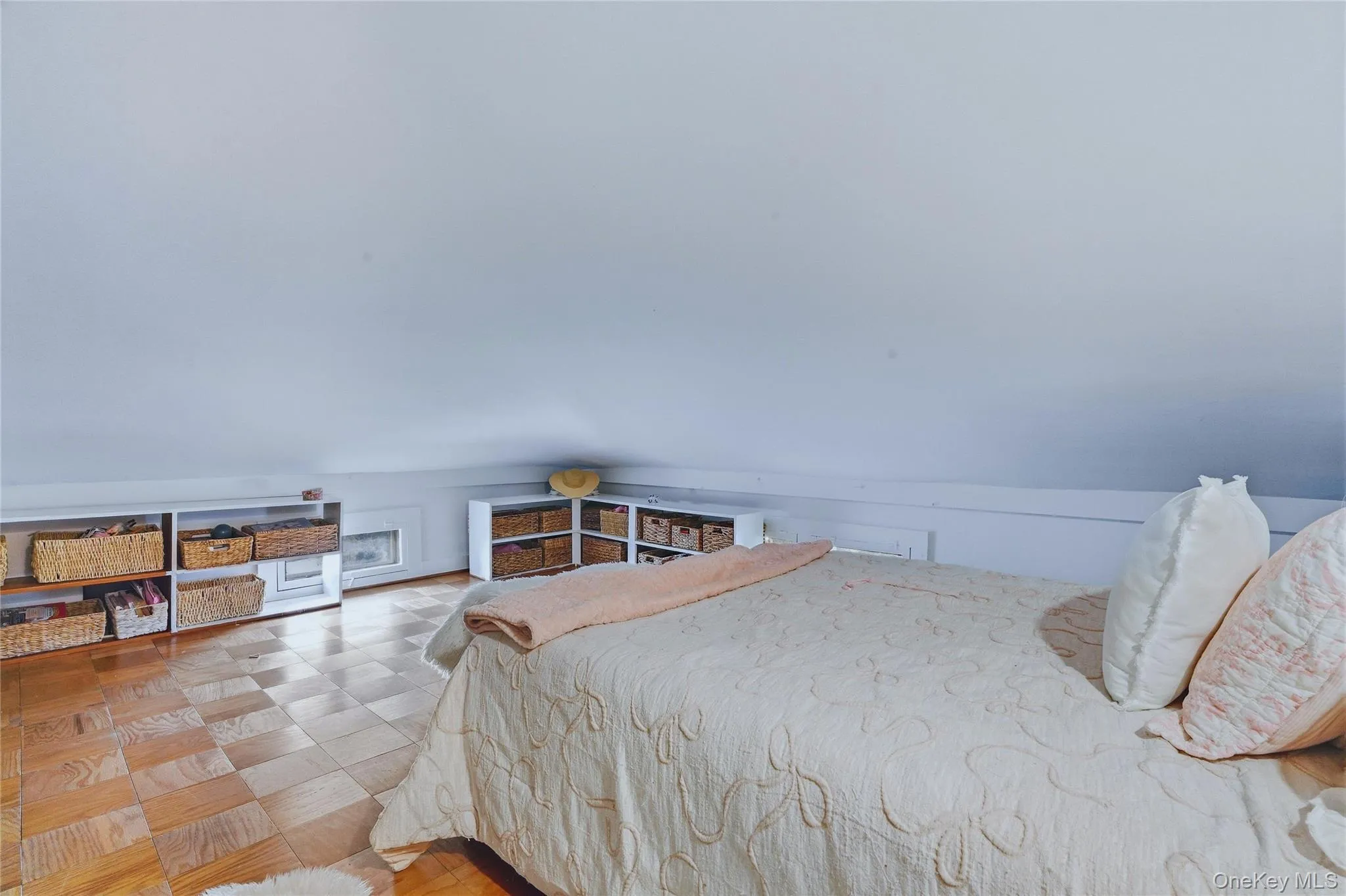 Sloped ceiling, wood-finish flooring, and built-in shelving Sloped ceiling, wood-finish flooring, and built-in shelving
