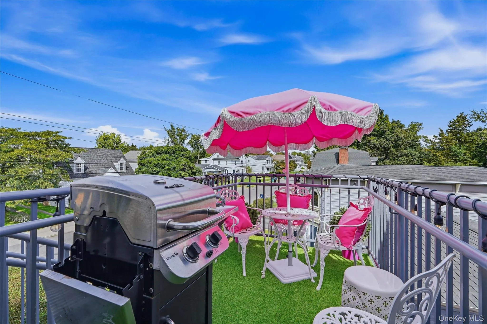 Rooftop balcony featuring metal railings and an artificial turf surface Rooftop balcony featuring metal railings and an artificial turf surface