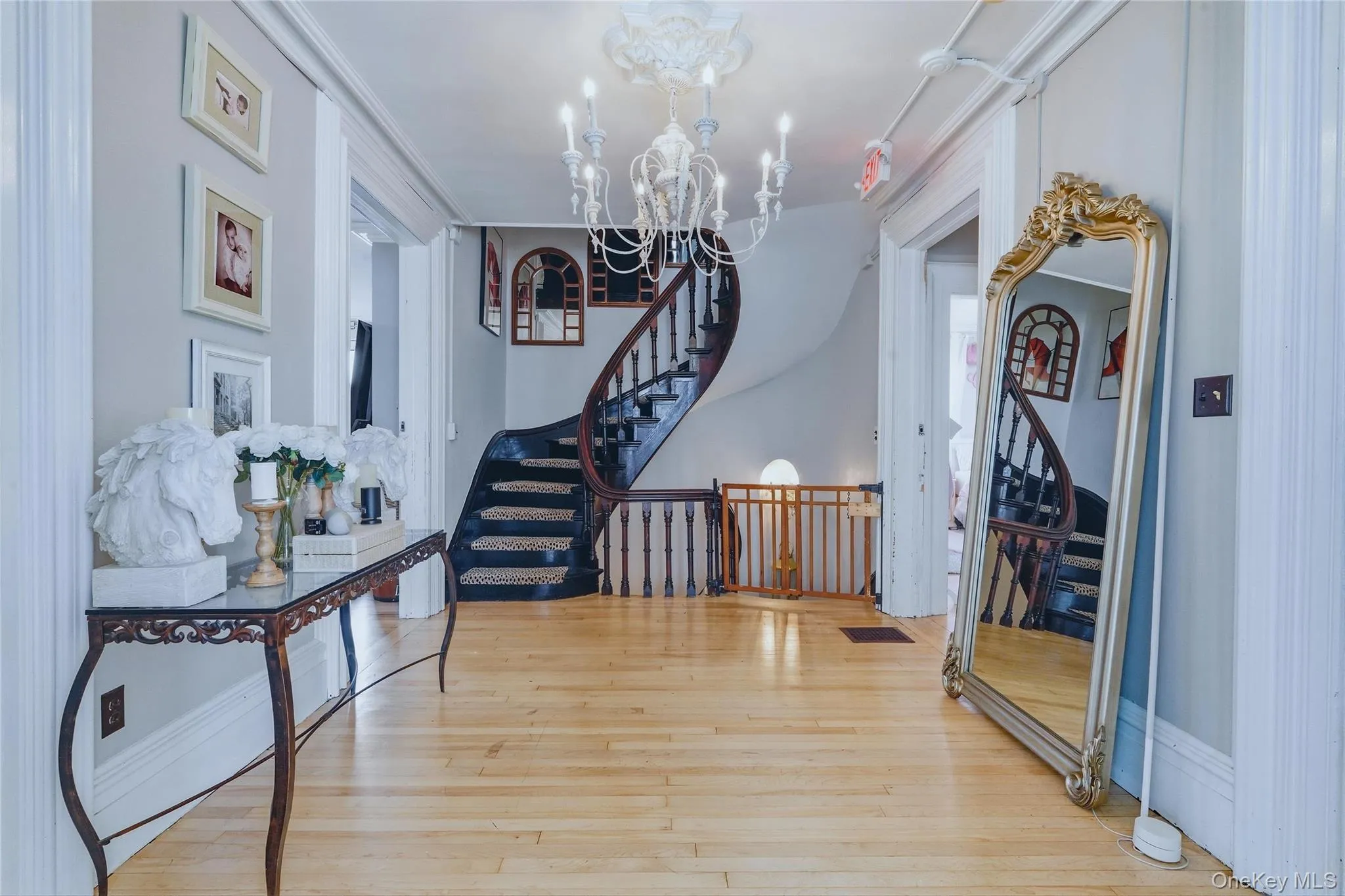 Wood-finish flooring, a curved staircase with dark wood treads, and white balusters Wood-finish flooring, a curved staircase with dark wood treads, and white balusters