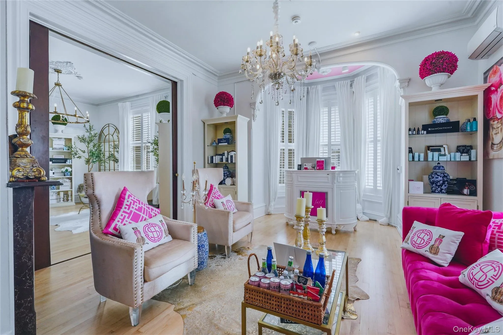 Hardwood flooring, ornate chandelier, decorative crown molding, built-in shelving, and large windows with plantation shutters Hardwood flooring, ornate chandelier, decorative crown molding, built-in shelving, and large windows with plantation shutters