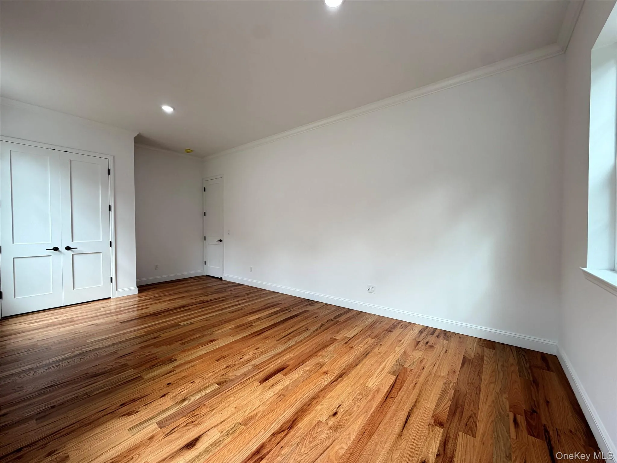 Hardwood flooring, recessed ceiling lighting, crown molding, white trim, and a double-door entry Hardwood flooring, recessed ceiling lighting, crown molding, white trim, and a double-door entry